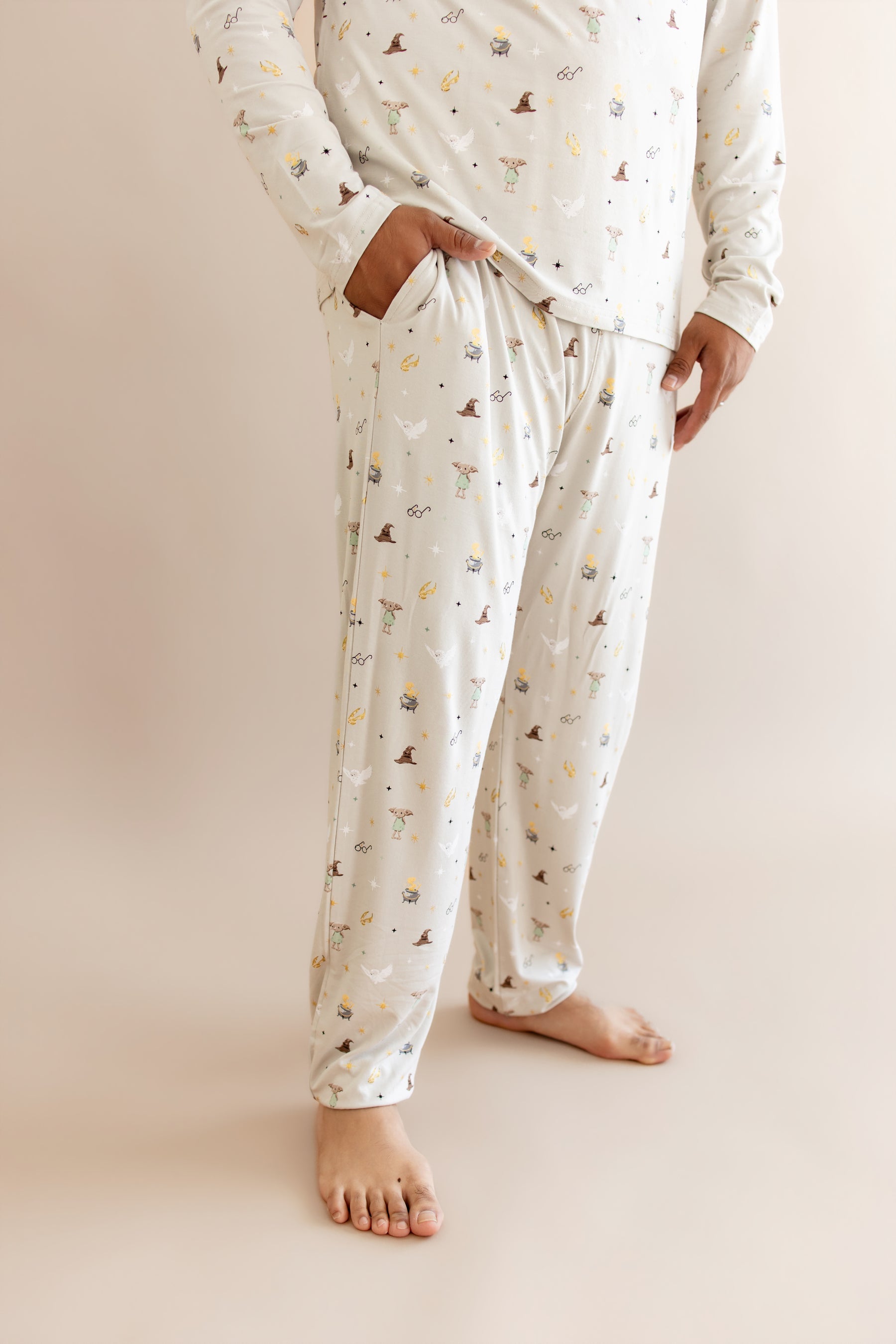 Person wearing men's jogger set pajama with pocket having Harry Potter prints on cream fabric