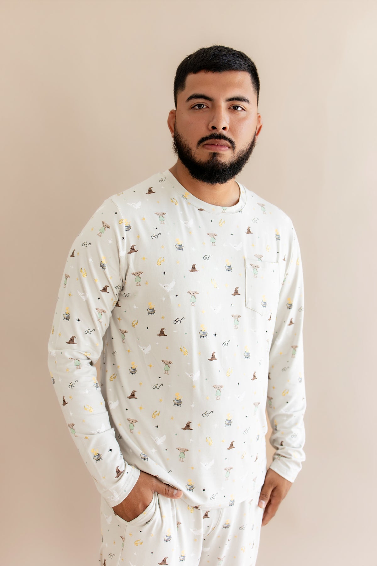 Person wearing a cream Men's jogger set with Harry Potter prints on a beige background