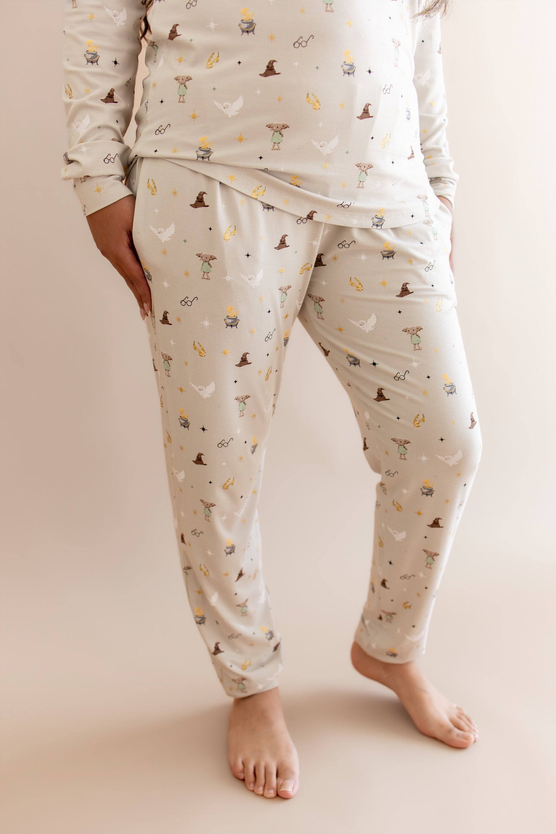 Women showcasing a beige Harry Potter patterned jogger pajama with pocket on a beige background
