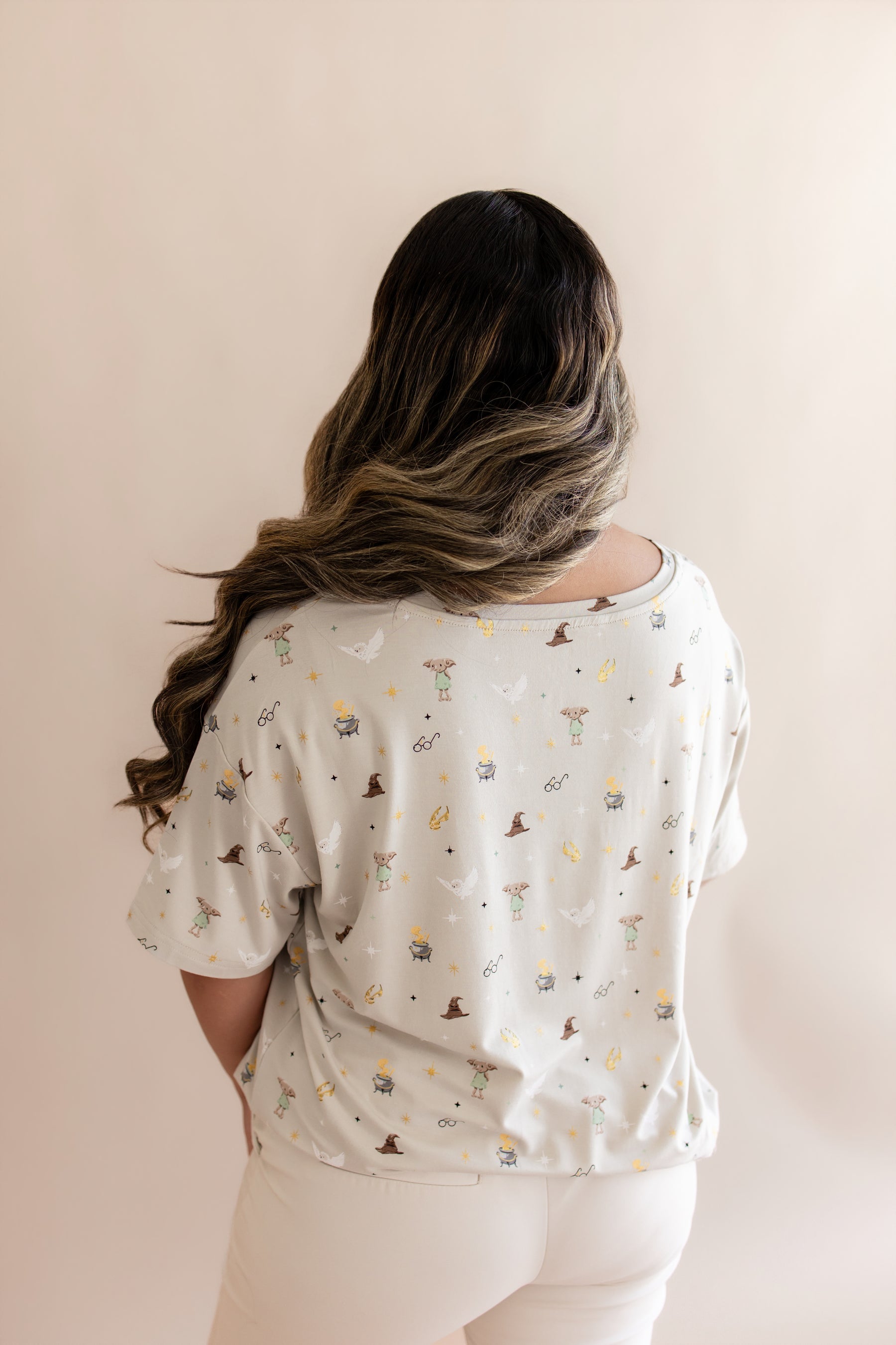 Back side of Women's Relaxed Fit V-Neck with Harry Potter prints on a beige background
