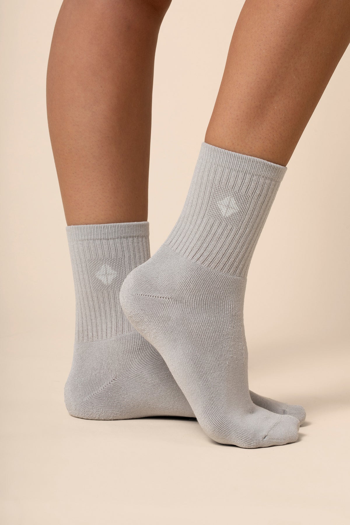 Gray socks worn by a person on a beige background