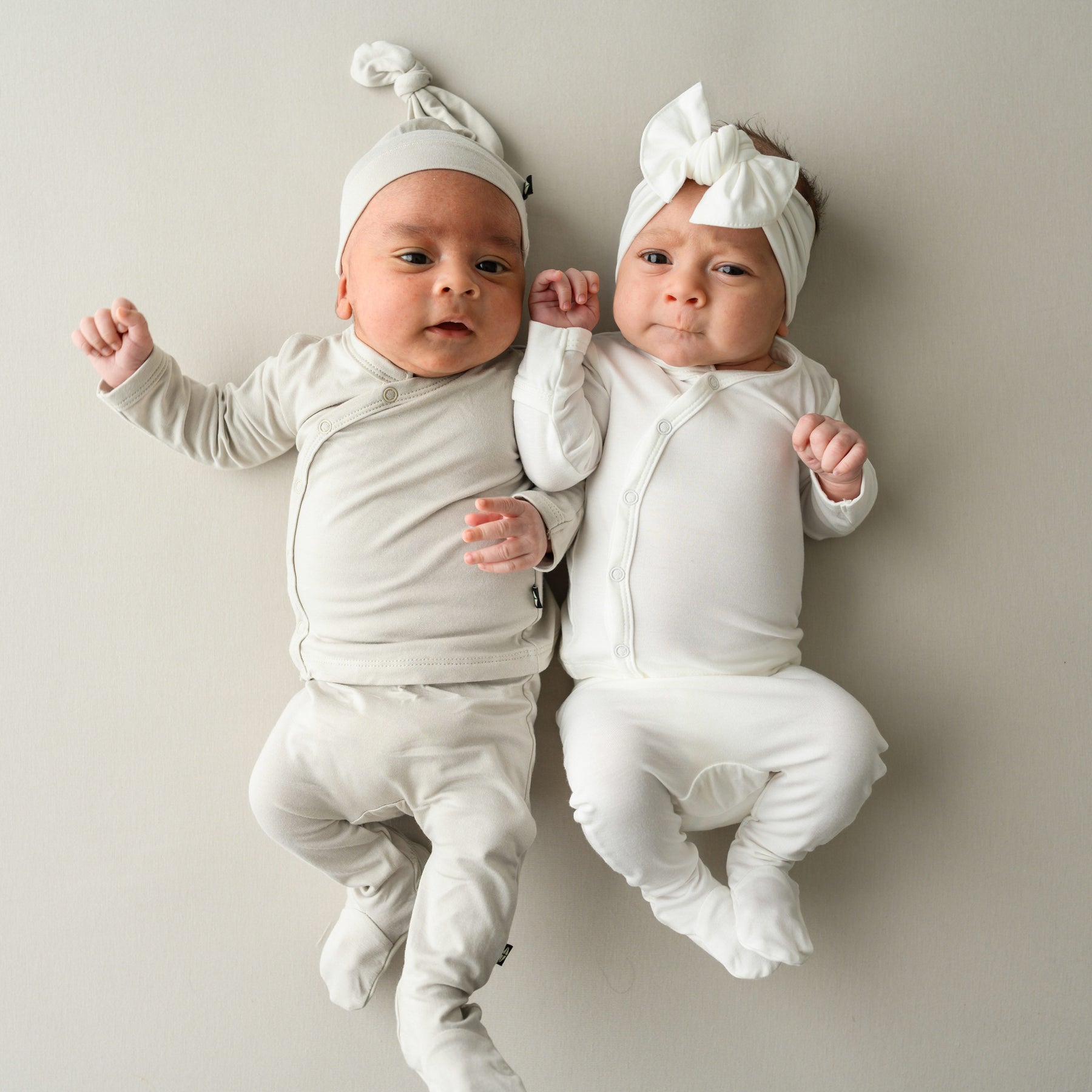 Babies wearing Hospital Take Me Home Set with Cap in Oat and Take Me Home Set with Bow in Cloud 