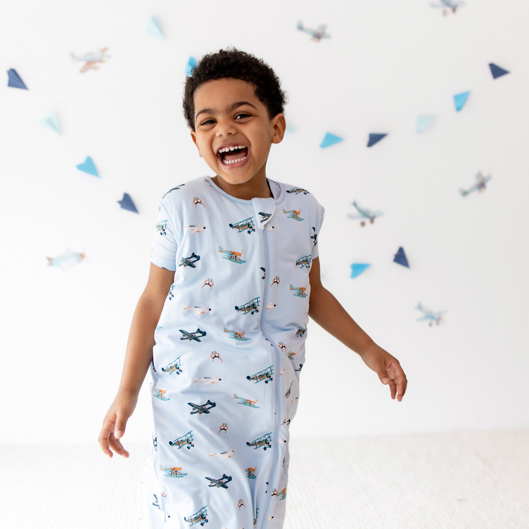 Smiling boy walking wearing the Sleep Bag Walker in Take Off 1.0