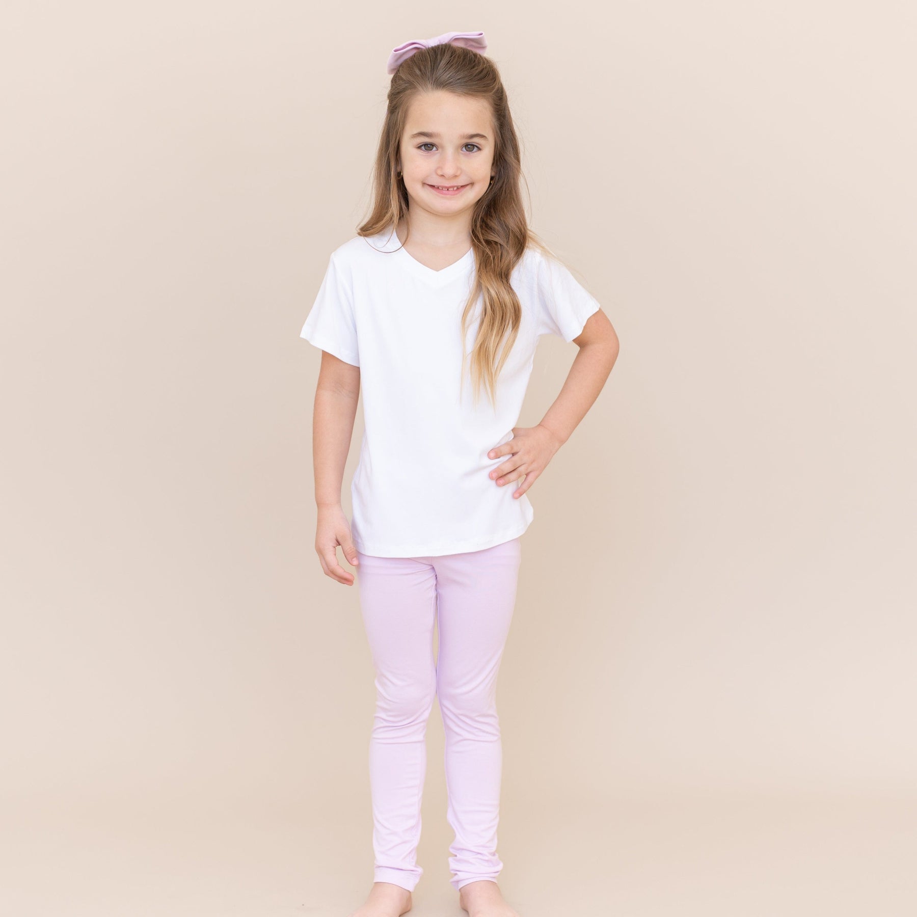 Young girl modeling the Toddler Leggings in Thistle paired with a white vneck
