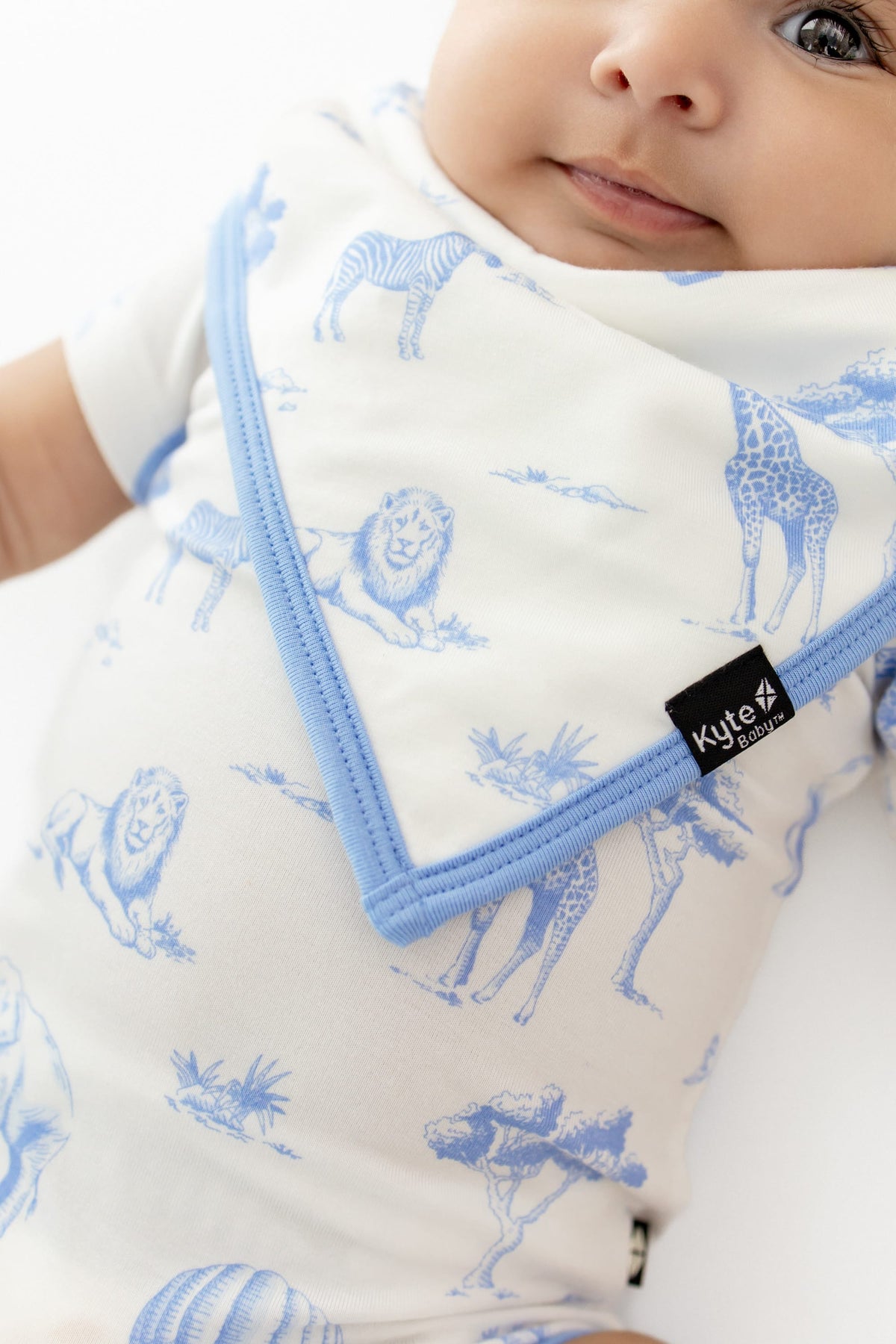 Close up of the Bib in Toile Safari on an infant wearing the matching bodysuit
