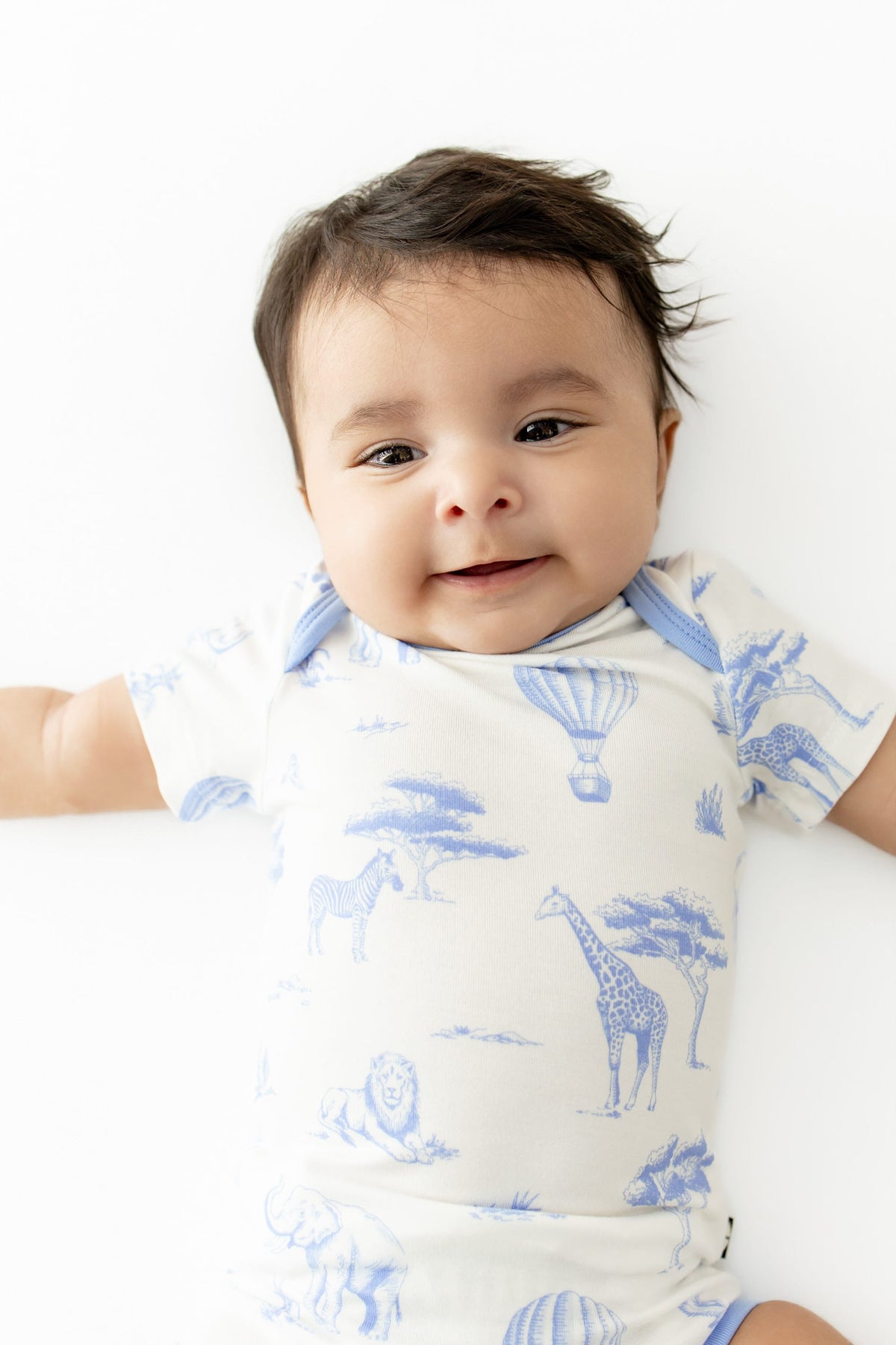 Close up of infant wearing the Bodysuit in Toile Safari