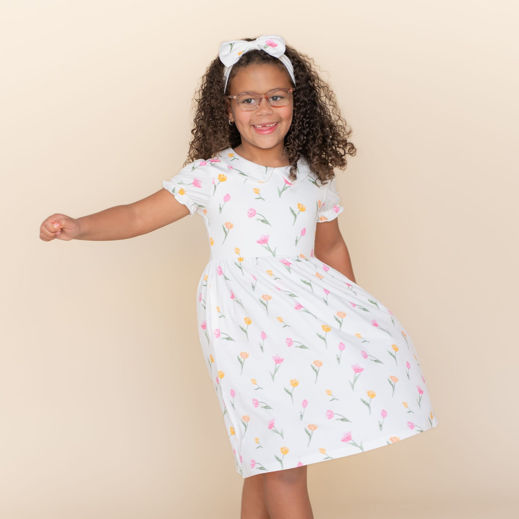 Young girl modeling with her hand in the pocket of the Peter Pan Collar Dress in Tulip
