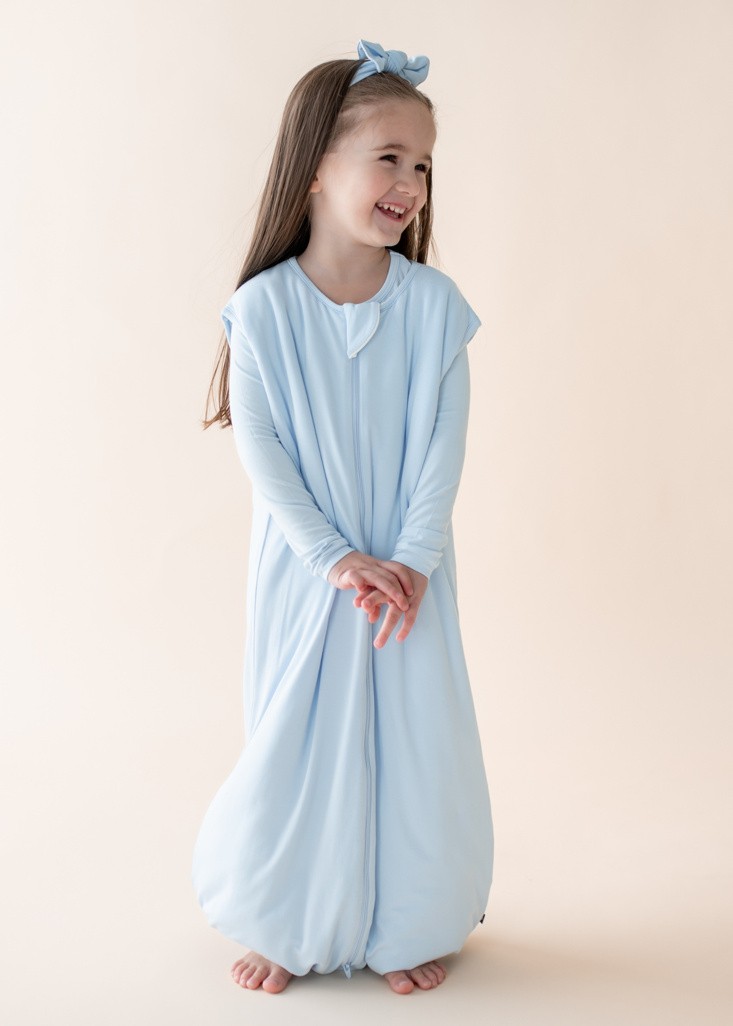 Young child in a light blue sleep bag walker