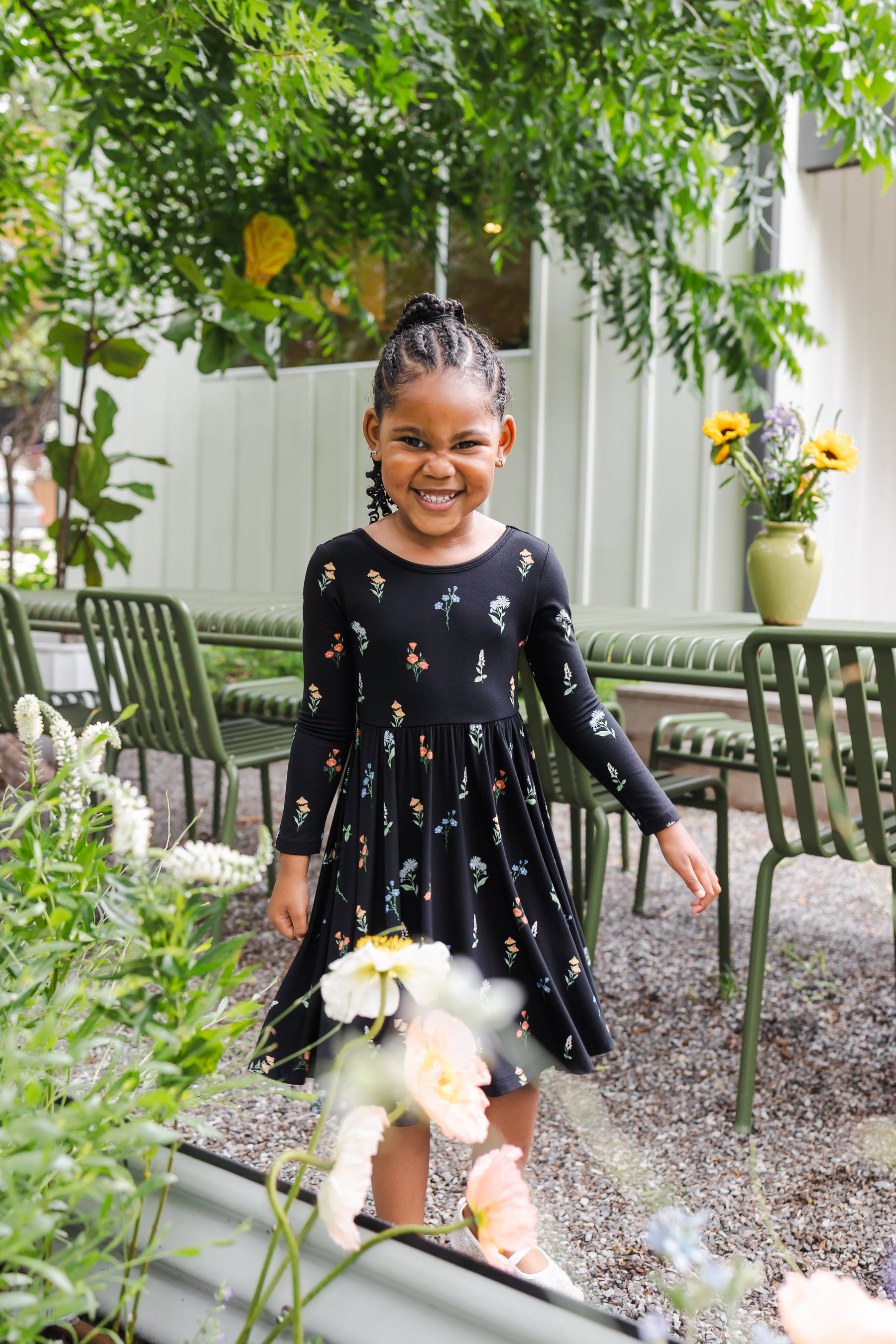 Girl smiling outdoors under a tree wearing Long Sleeve Twirl Dress in Midnight Wildflower print
