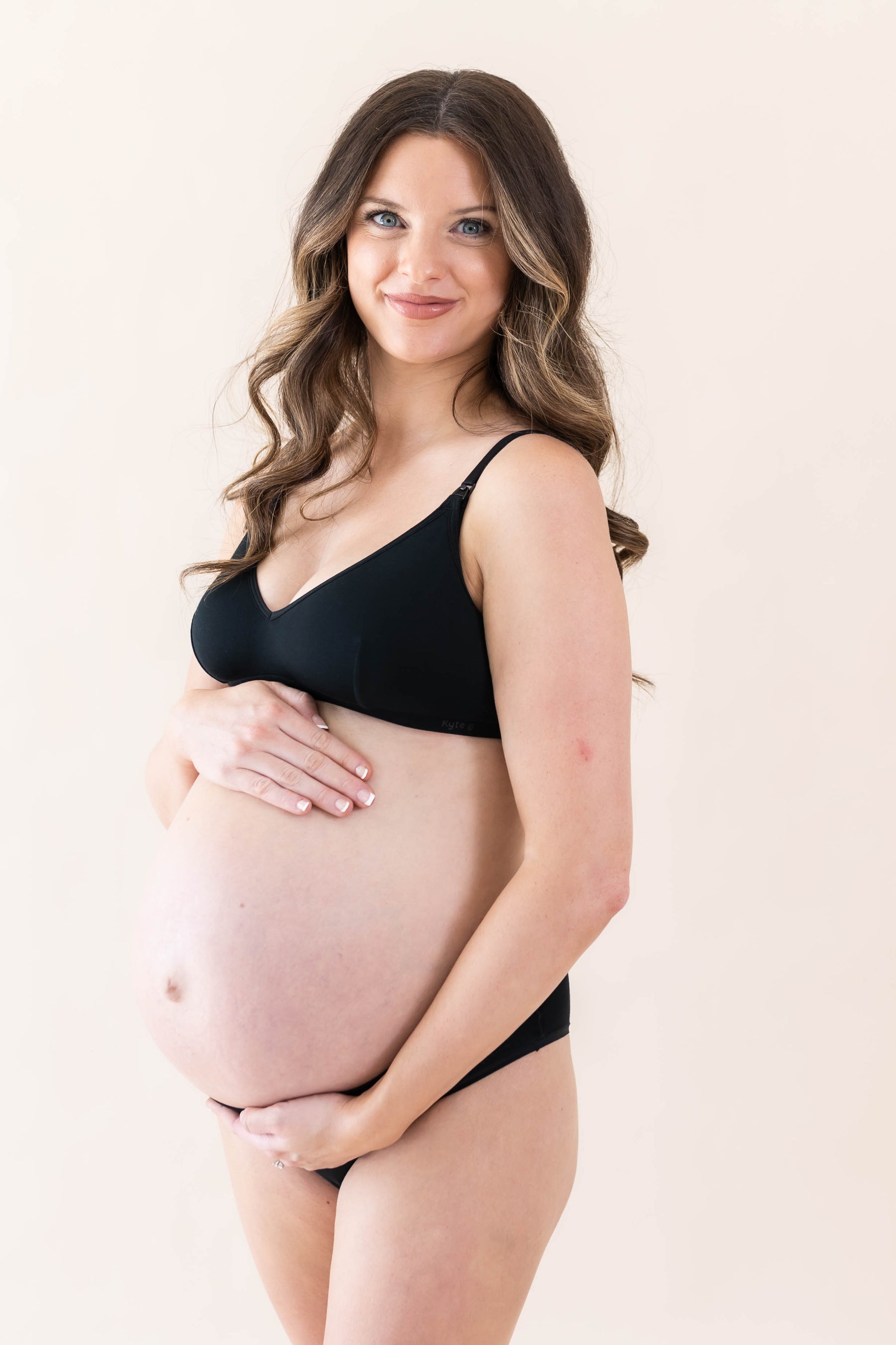 Expectant mother wearing the Women's Nursing Bra in Midnight with matching underwear