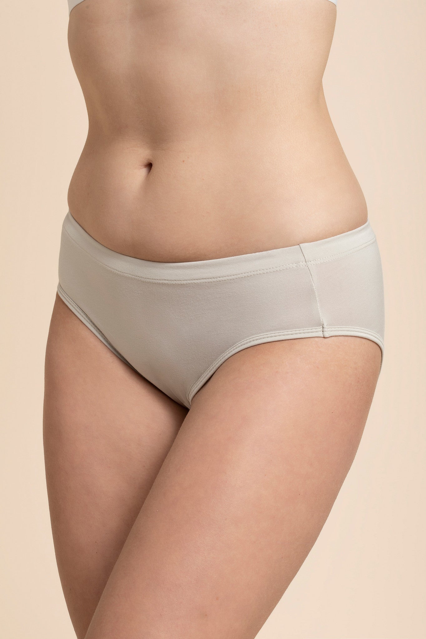 Beige underwear worn by a person on a beige background