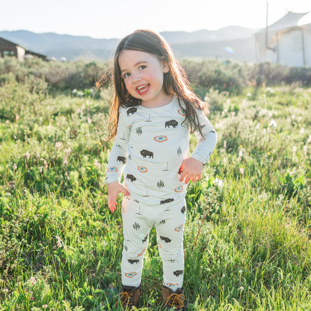 toddler wearing yellowstone long sleeve pajamas in a field