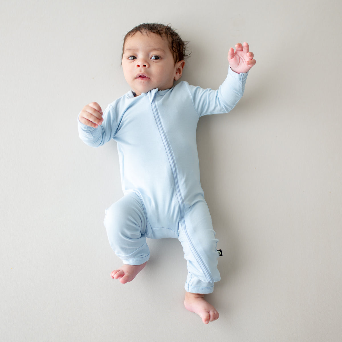 Baby wearing light blue romper with zipper