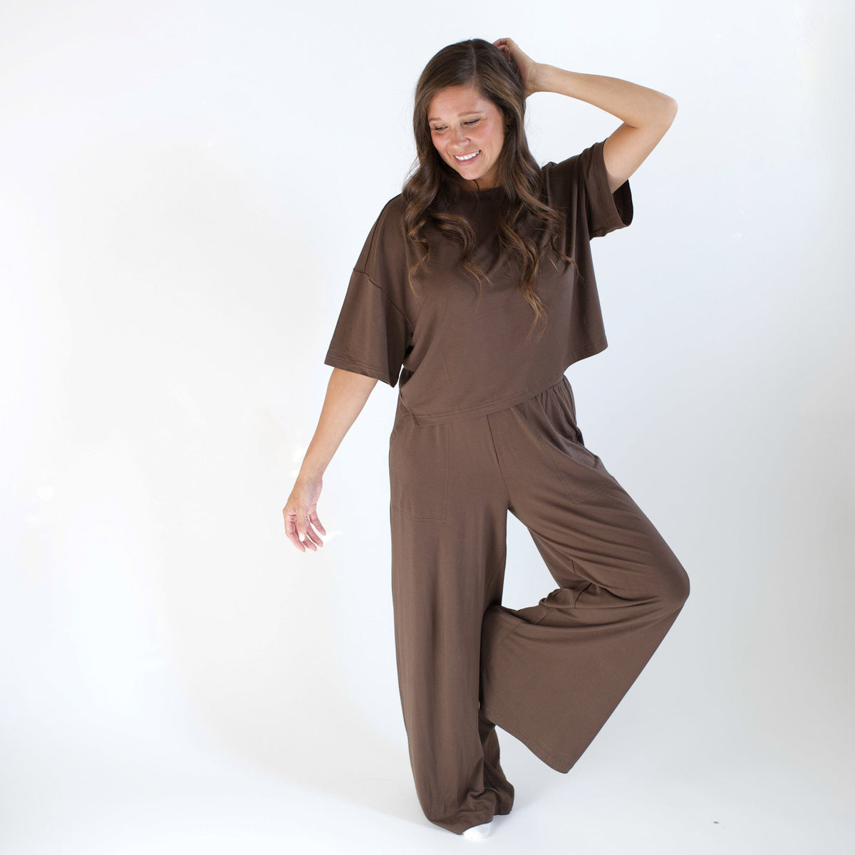 Woman wearing brown outfit with a boxy top and wide leg pant 