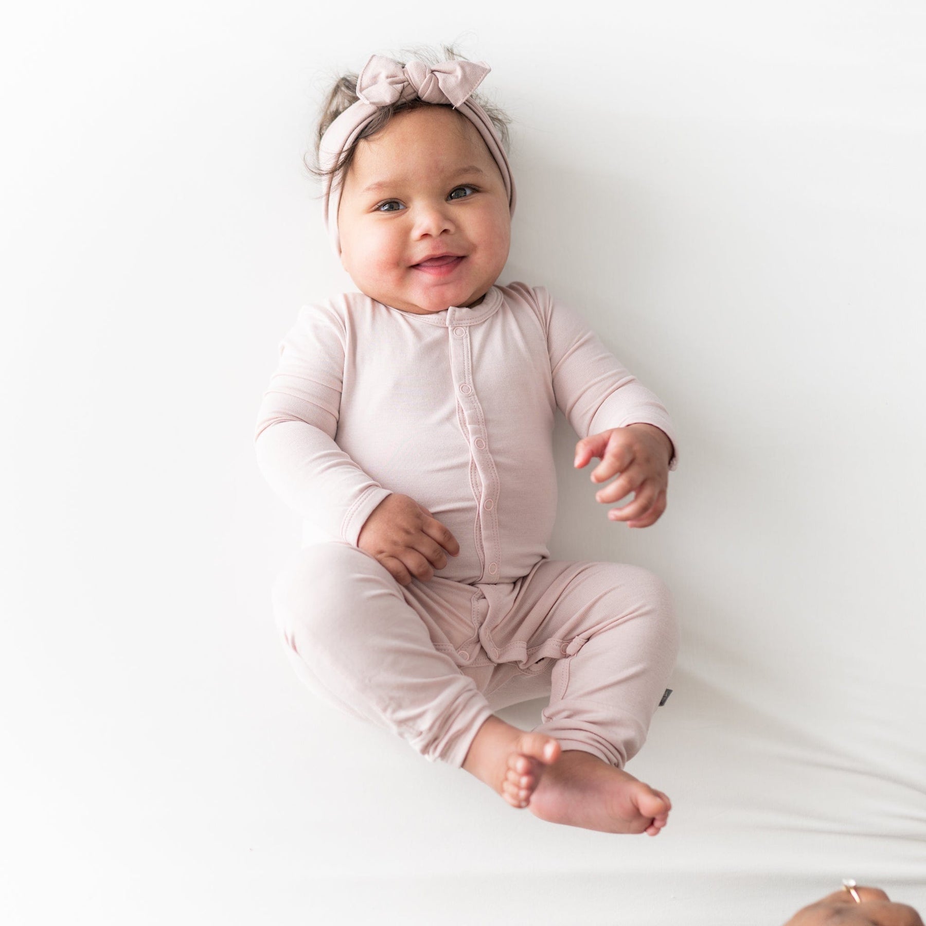Smiling infant  wearing Bow in Blush and a matching  Snap Romper