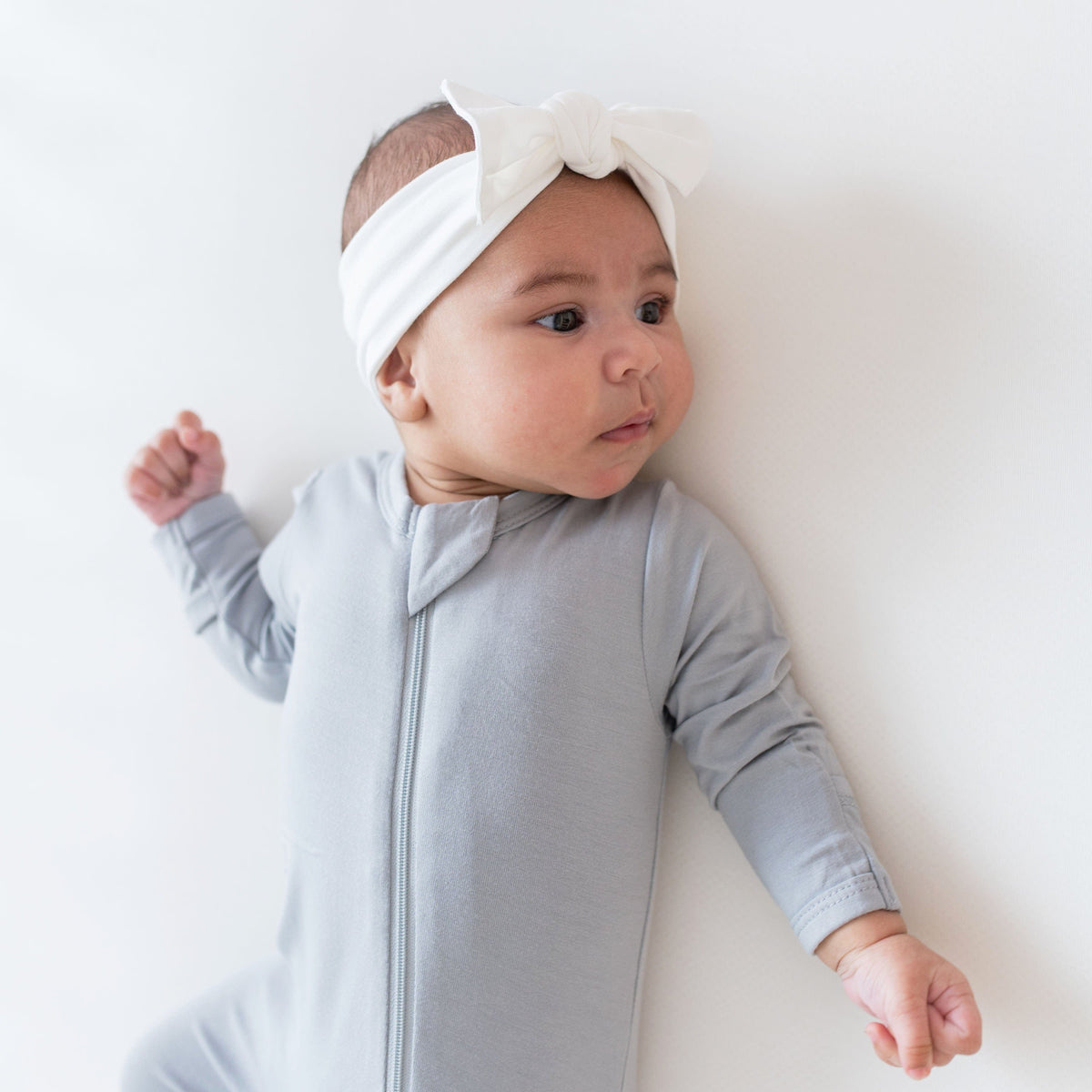 Infant wearing Kyte Baby Bow in Cloud