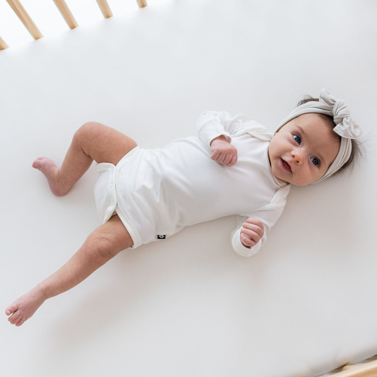 Infant wearing Bow headband in Oat and a Long Sleeve Bodysuit in Cloud