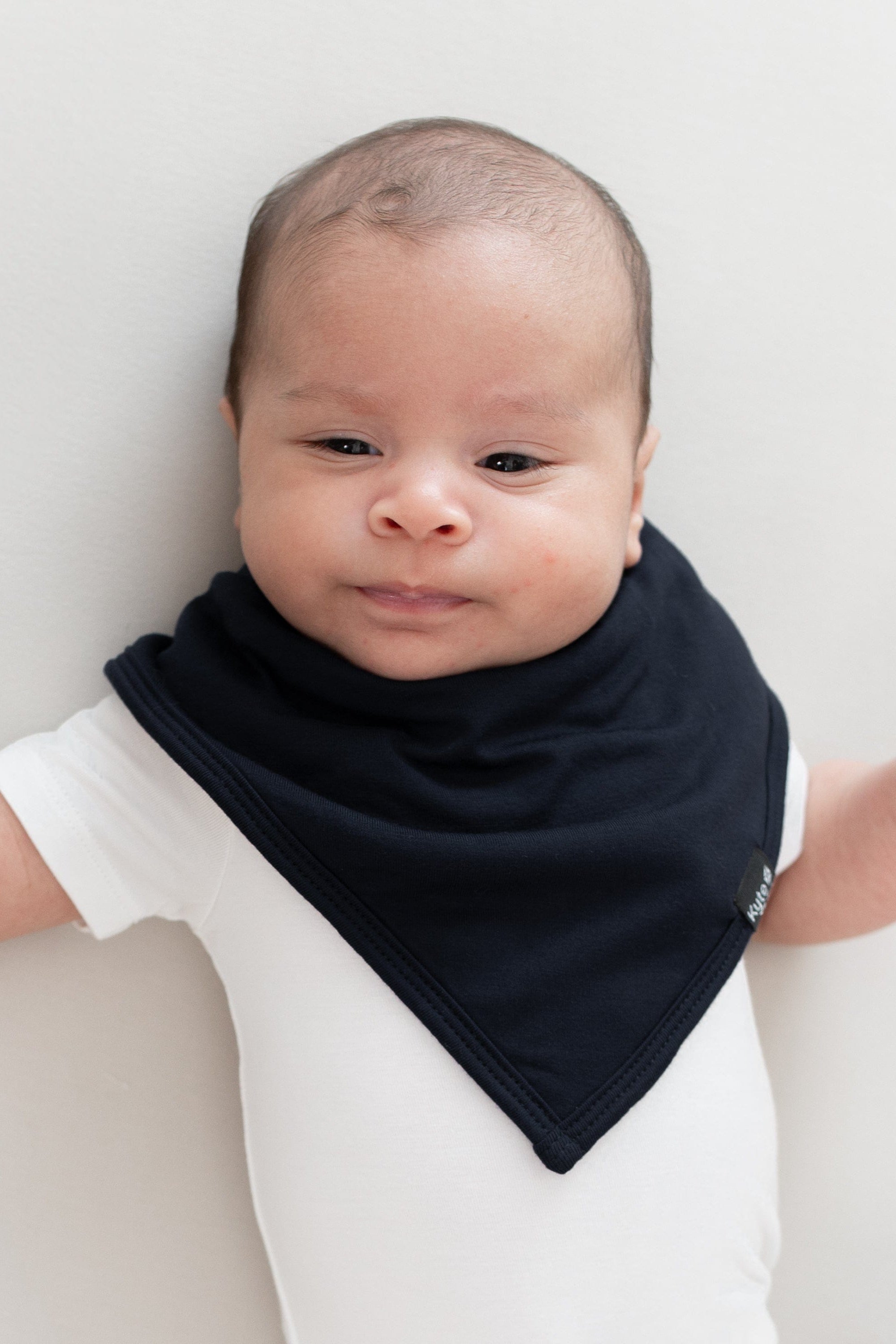Baby wearing the Kyte Baby Bib in Midnight