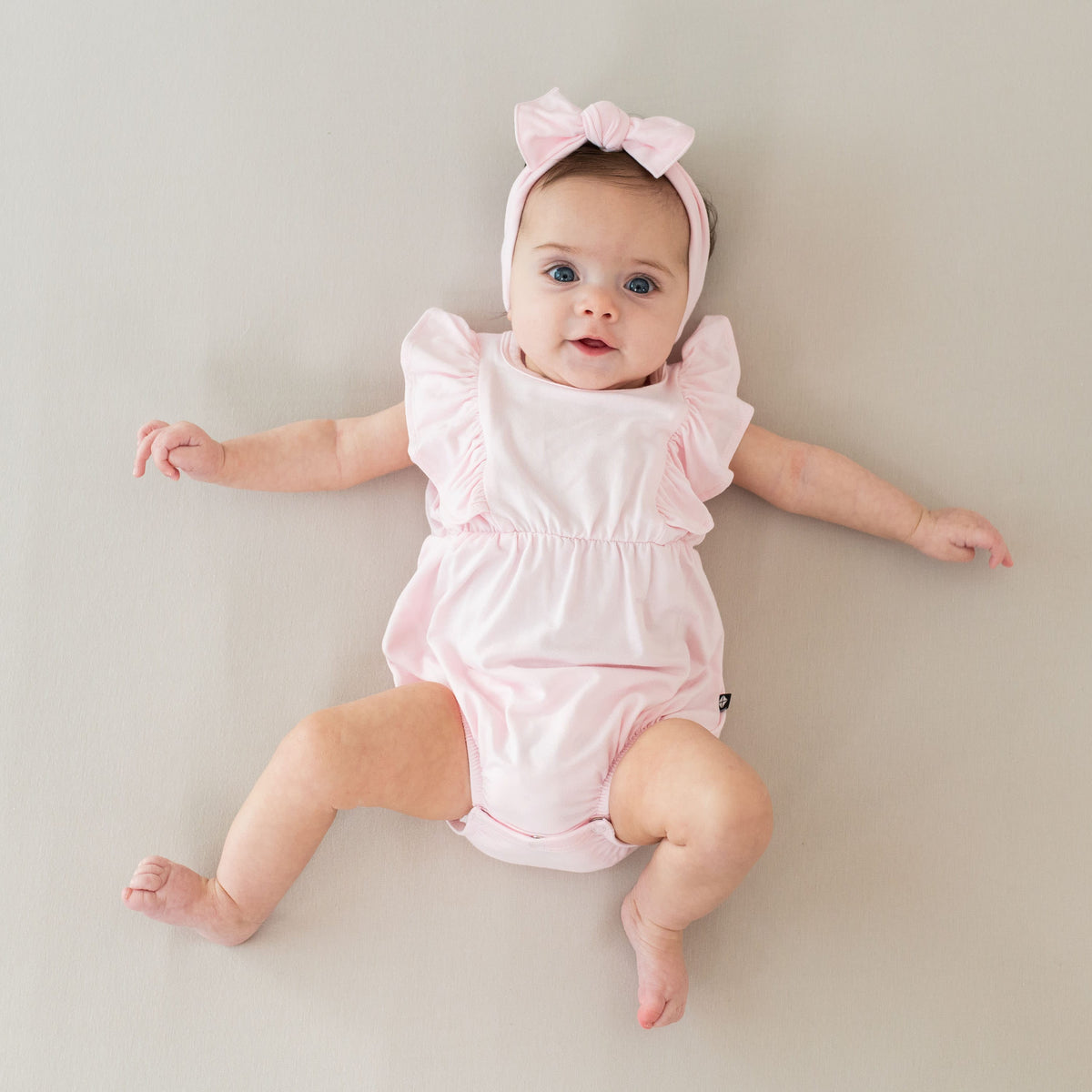 Infant wearing Kyte Baby Bubble Romper in Sakura
