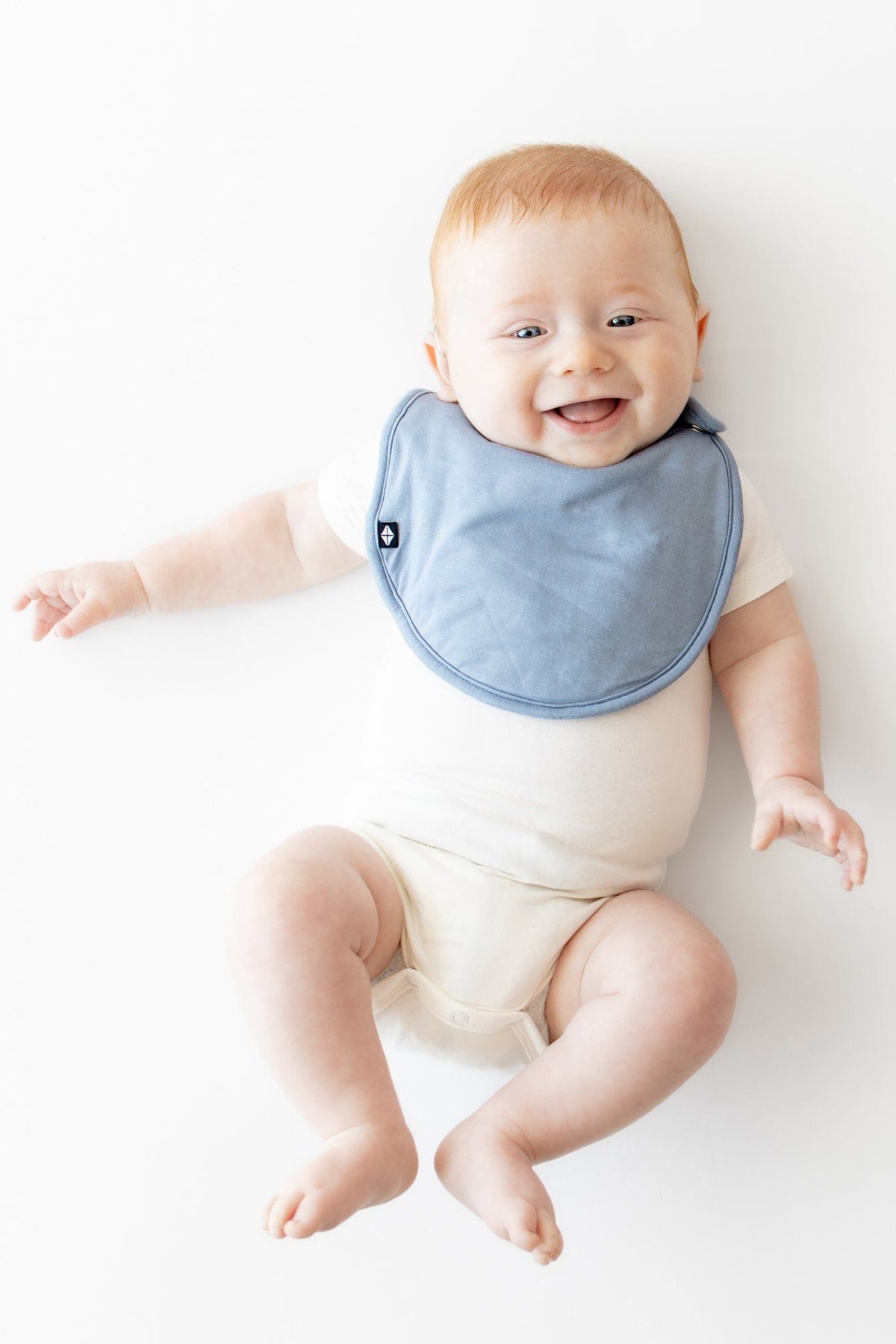 Infant wearing Kyte Baby Cushy Bib with Adjustable Snaps in Slate