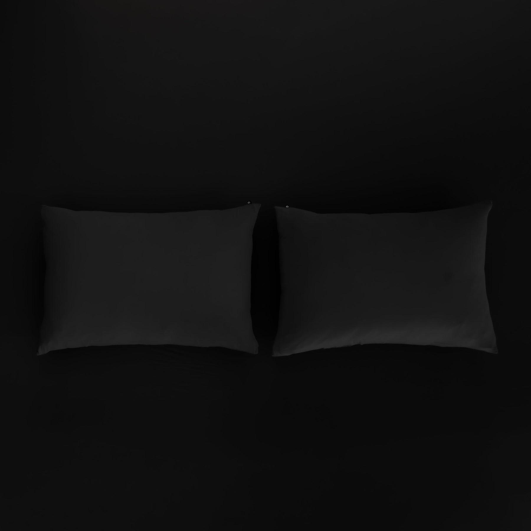 Kyte Baby Pillowcases in Midnight sitting on fitted sheet