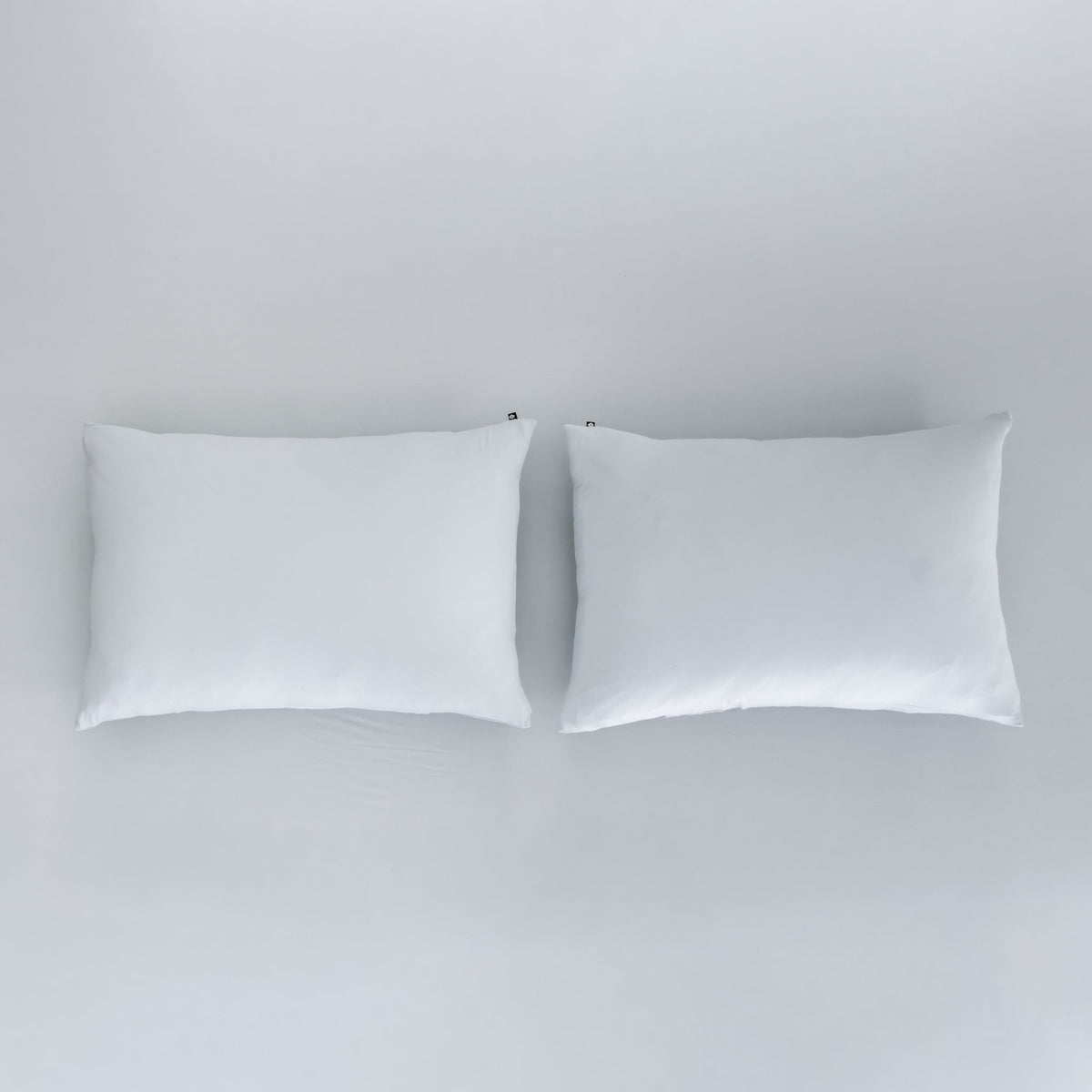 Kyte Baby Pillowcases in Storm sitting on top of Fitted Sheet