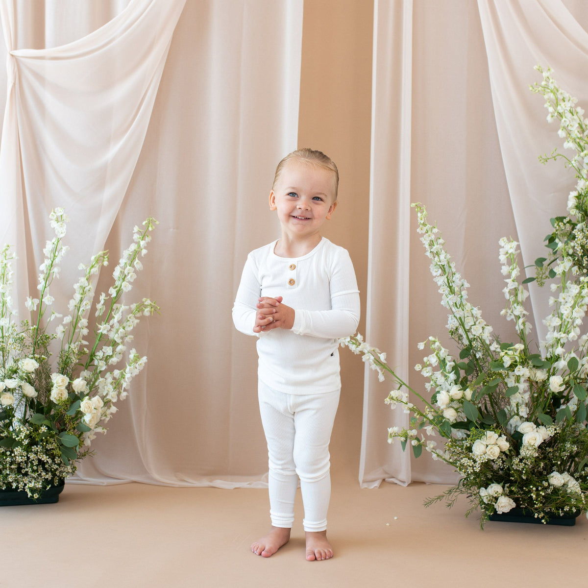 Smiling toddler wearing two piece Kyte Baby  Ribbed Henley Set in Cloud  