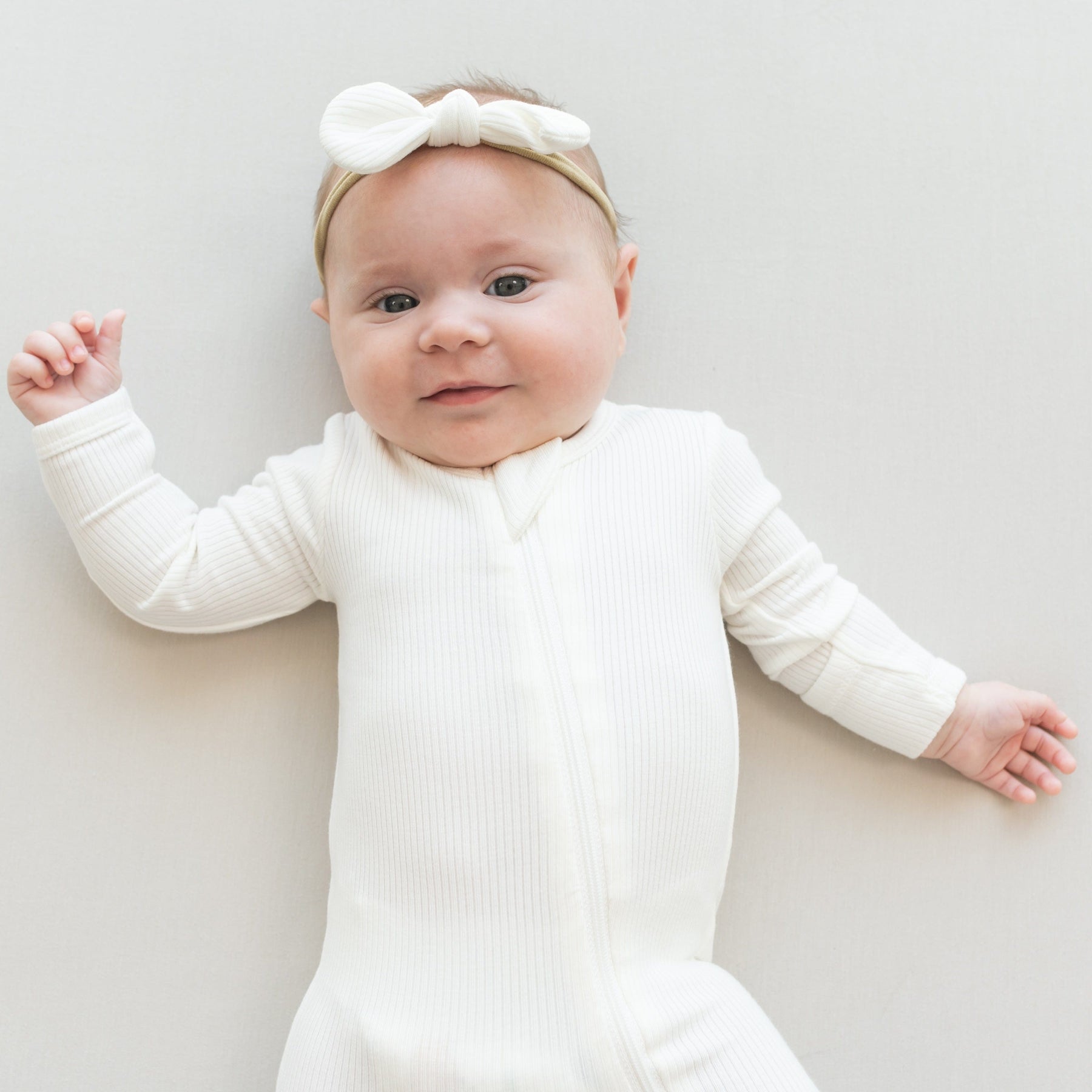 Infant wearing Kyte Baby Ribbed Bow with matching Nylon Band Bow in Cloud 