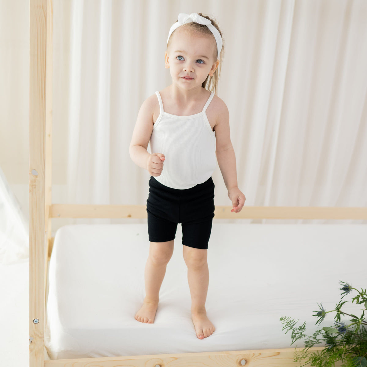 Toddler wearing Kyte Baby Ribbed 
Spaghetti Strap Bodysuit in Cloud