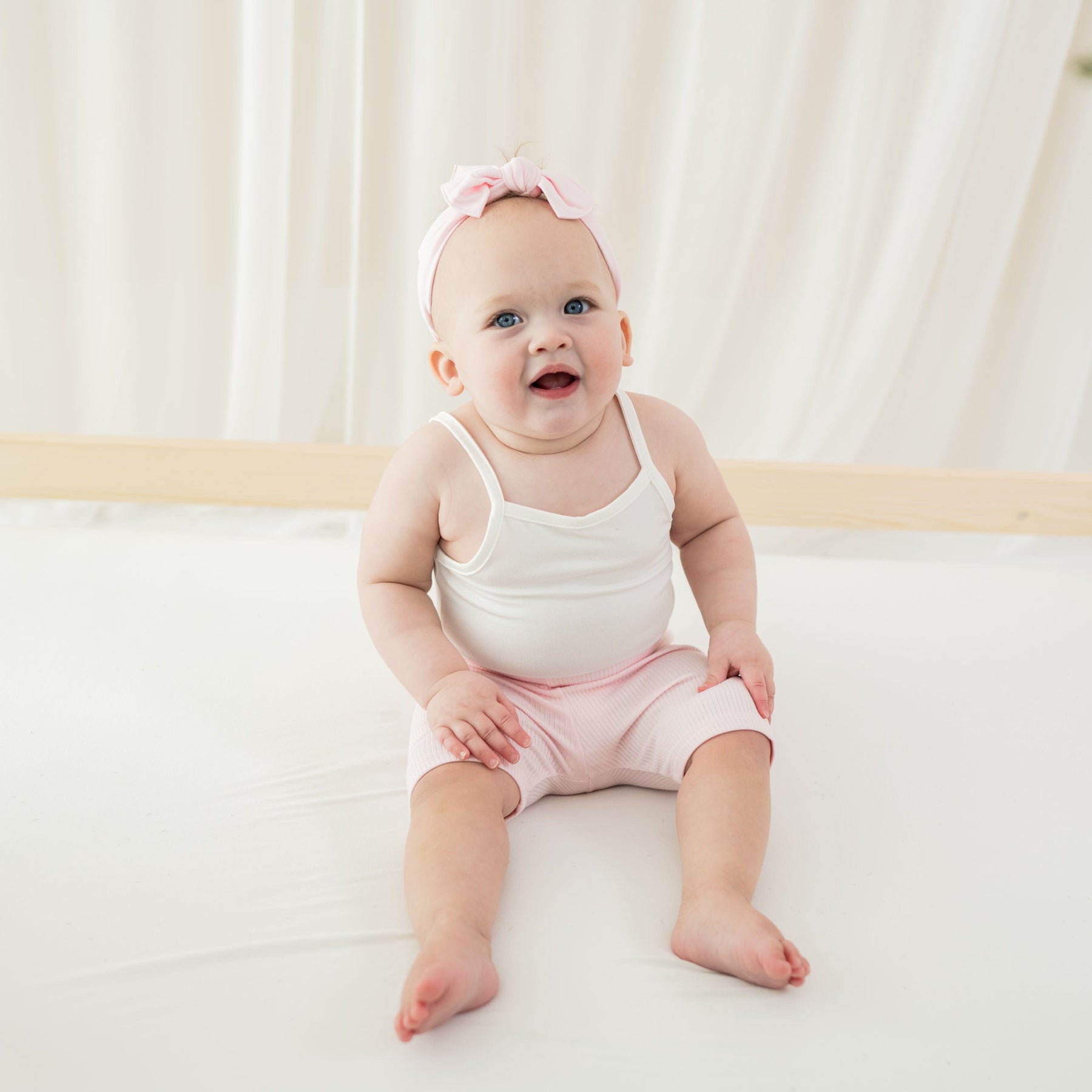 Girl wearing Kyte Baby Ribbed Toddler Bike Shorts in Sakura