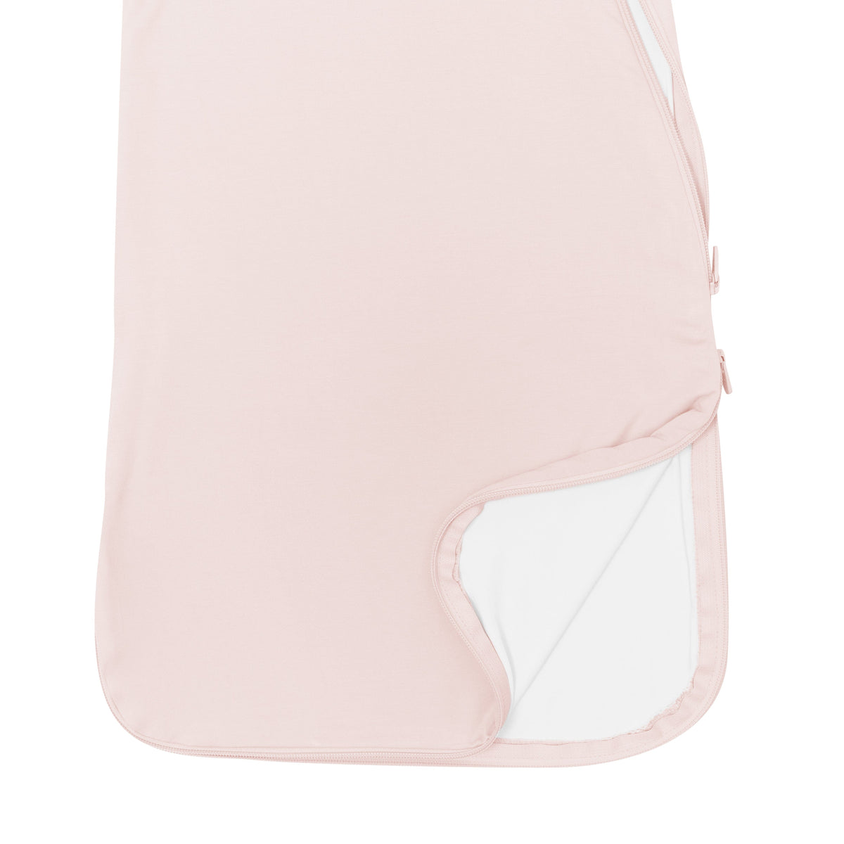 Close up of unzipped double zipper on Kyte Baby bamboo Sleep Bag in Blush 0.5 