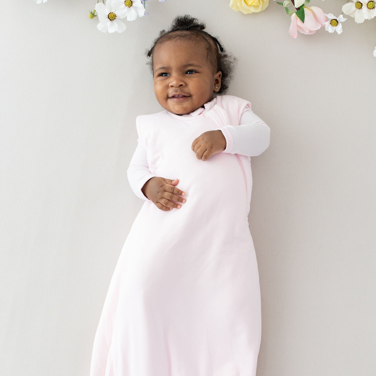 Baby wearing Kyte Baby bamboo Sleep Bag TOG 1.0 in Sakura pink