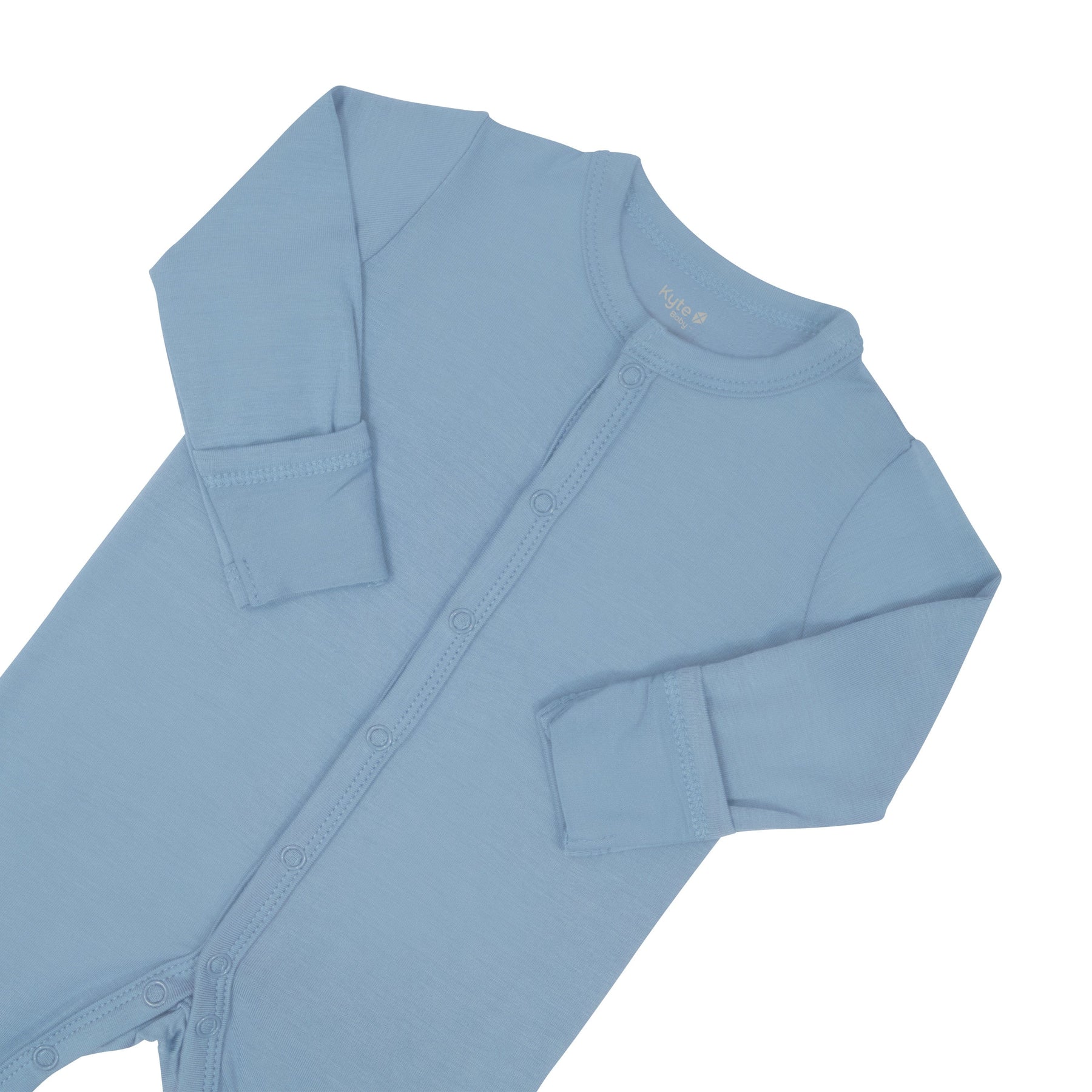 Close up of top portion of the Kyte Baby Romper in Slate with arms folded in 