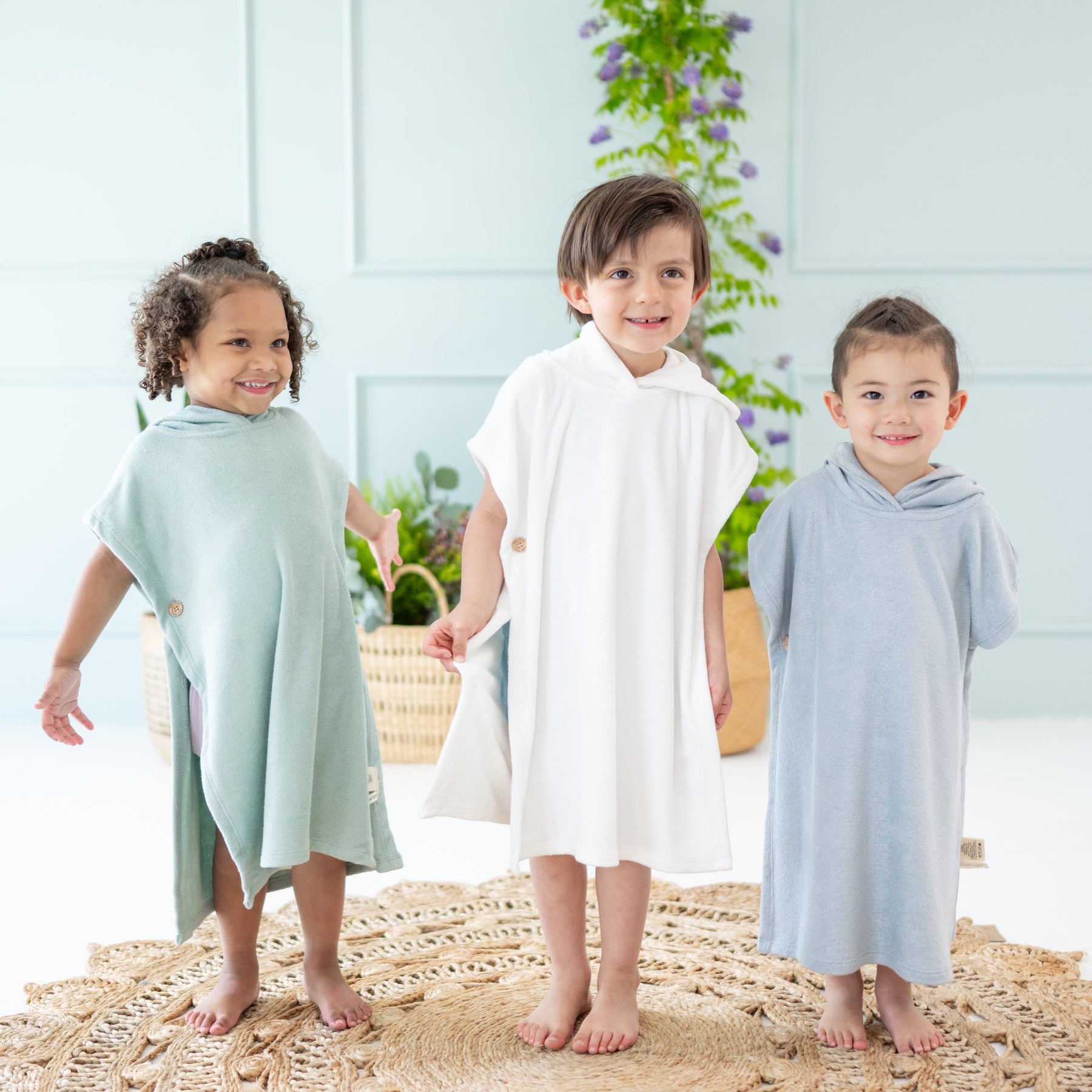 Toddlers wearing bamboo hooded Kyte Baby Swim  in Sage, Cloud and Fog