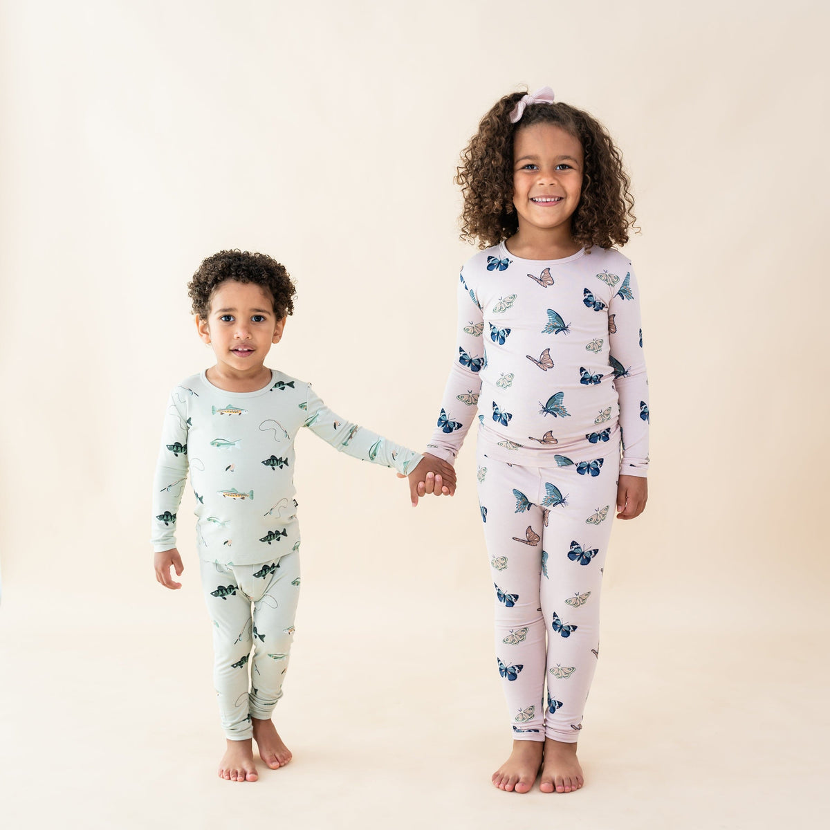 Kids wearing long sleeve pajama sets in fish and butterfly prints