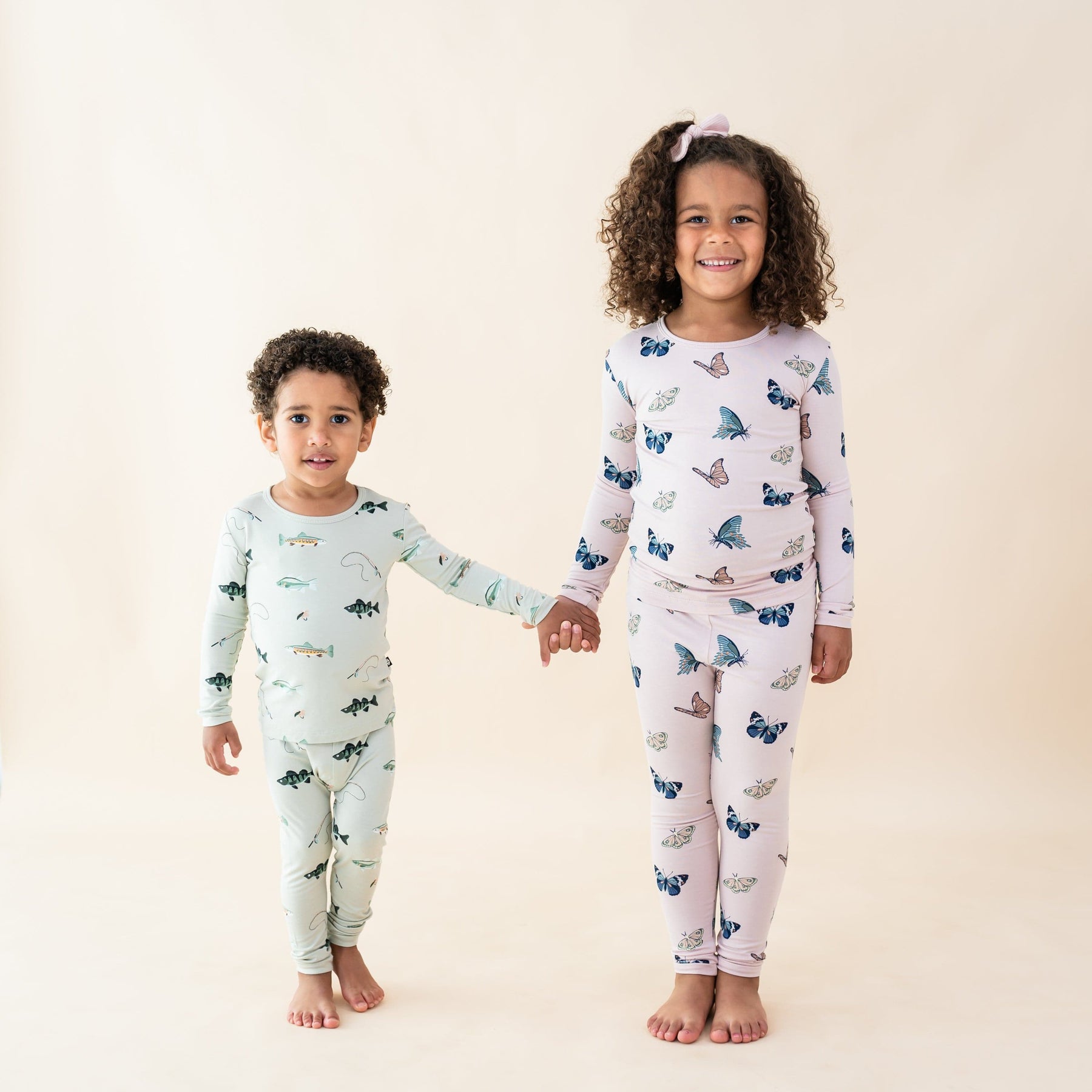 Kids wearing long sleeve pajama sets in fish and butterfly prints