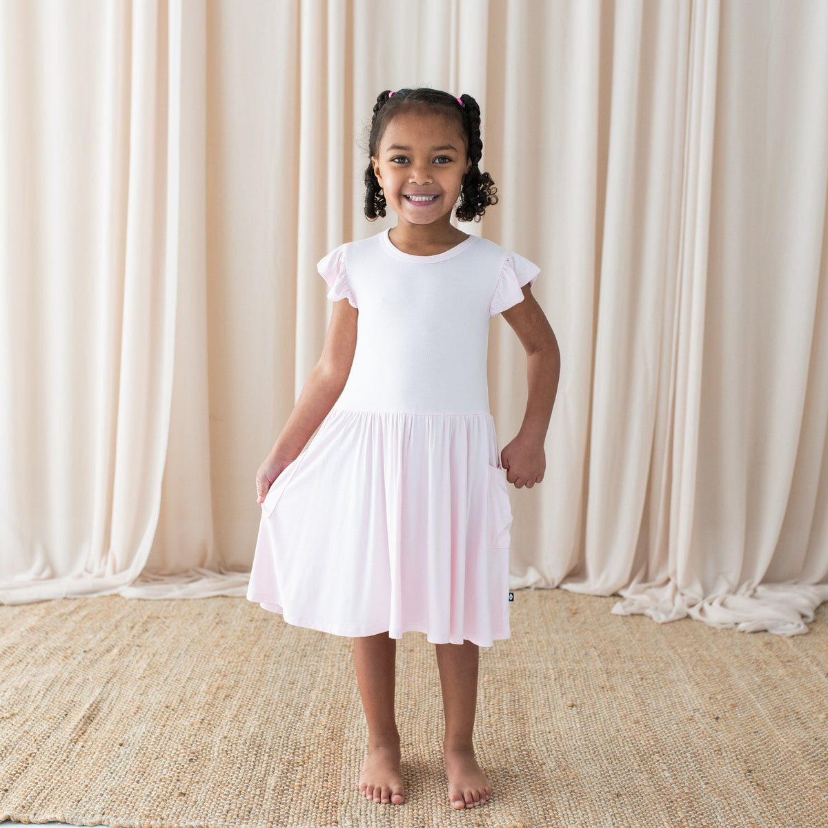 Girl wearing Kyte Baby Pocket Dress in Sakura