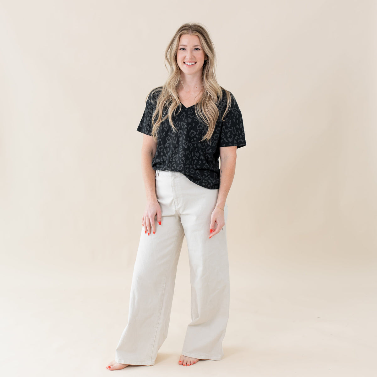 Woman wearing Kyte Baby Women's Relaxed Fit V-Neck tee in Midnight Leopard