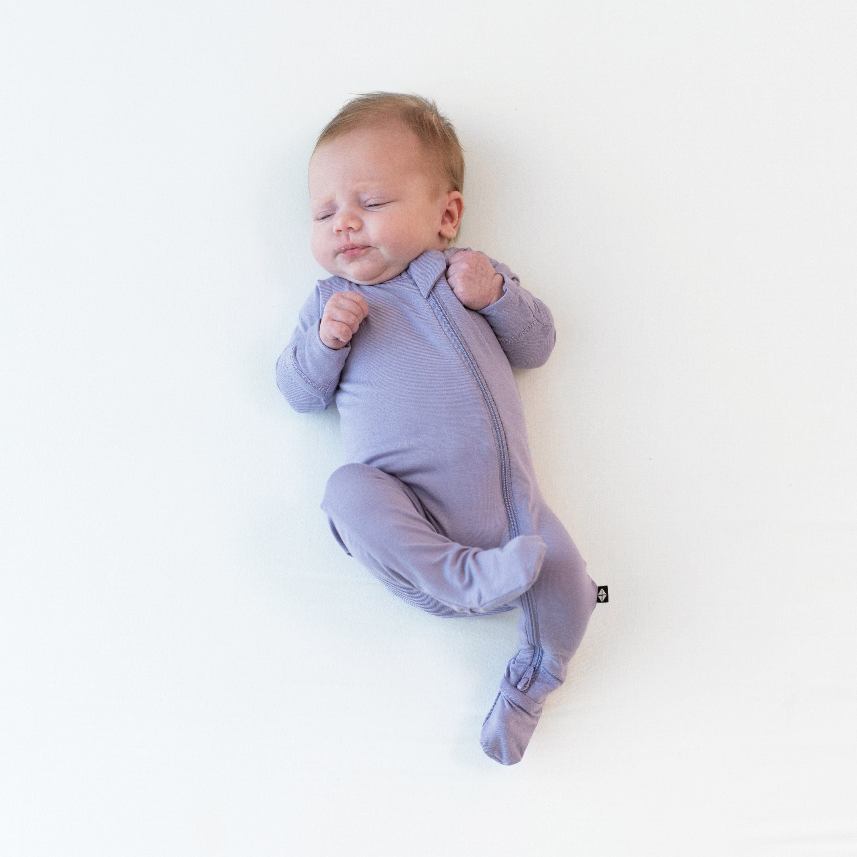 Newborn wearing Zippered Footie in Taro 