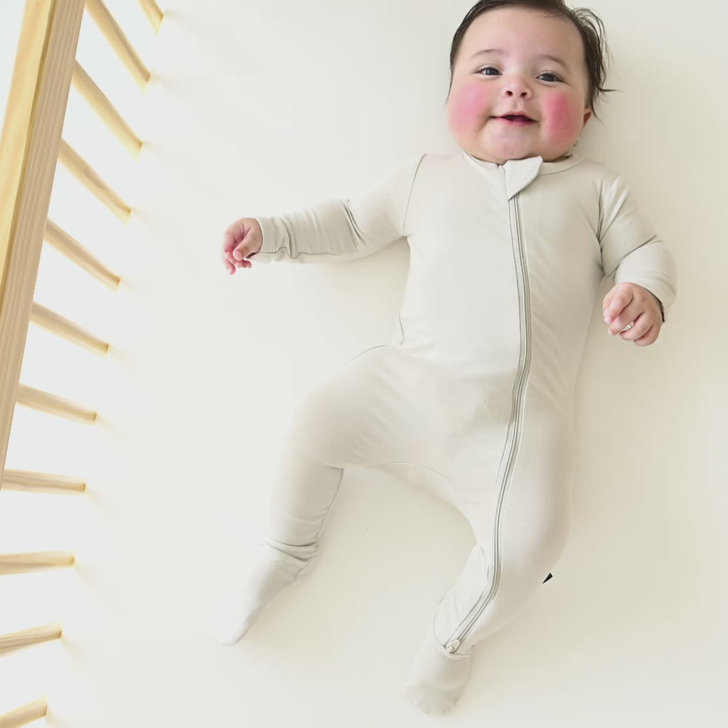 Video of infant laying in a crib wearing the Zippered Footie in Oat