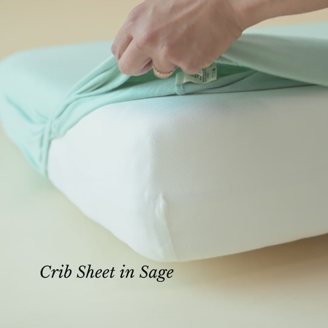 Video of crib sheet in Sage being put on a mattress