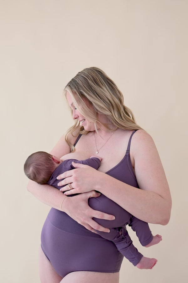 Female nursing her infant wearing the Women's Nursing Bra in Currant