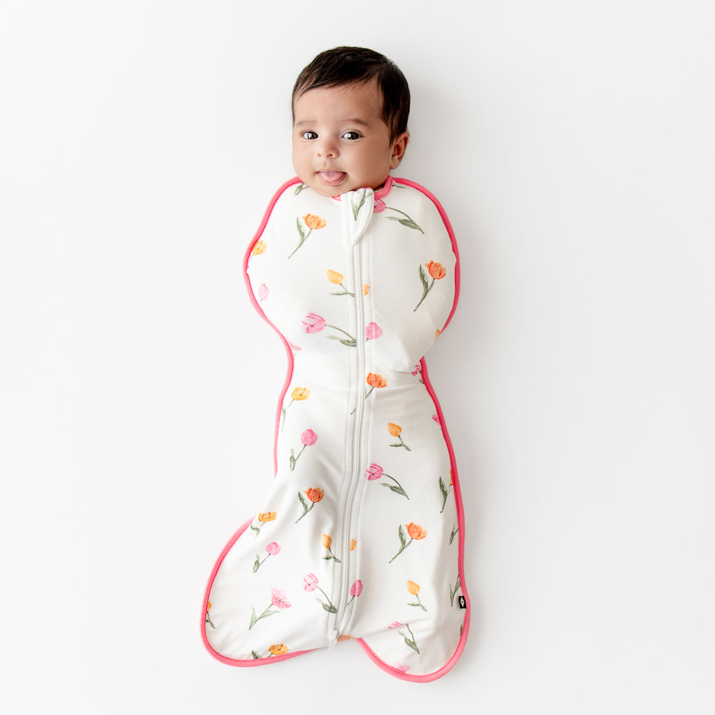 video of a baby being put into the kyte baby swaddle bag in a tulip print