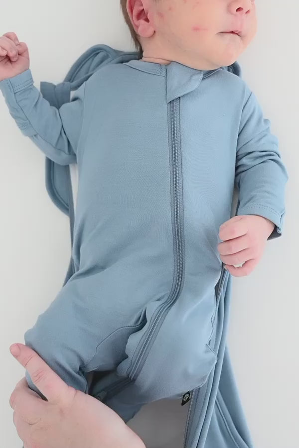 Baby being swaddled in a blue swaddle bag