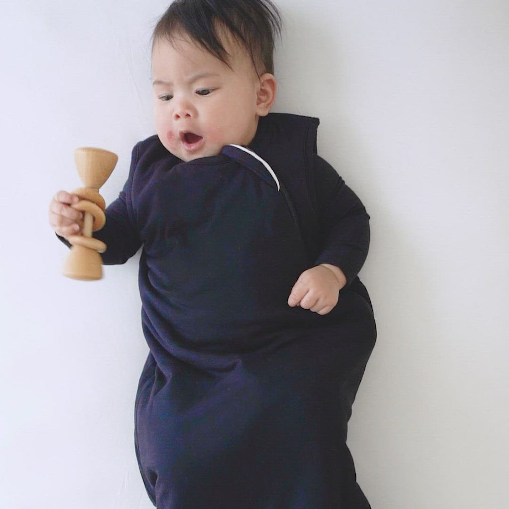 Video of baby shaking rattle while wearing Kyte Baby Sleep Bag in Navy 2.5