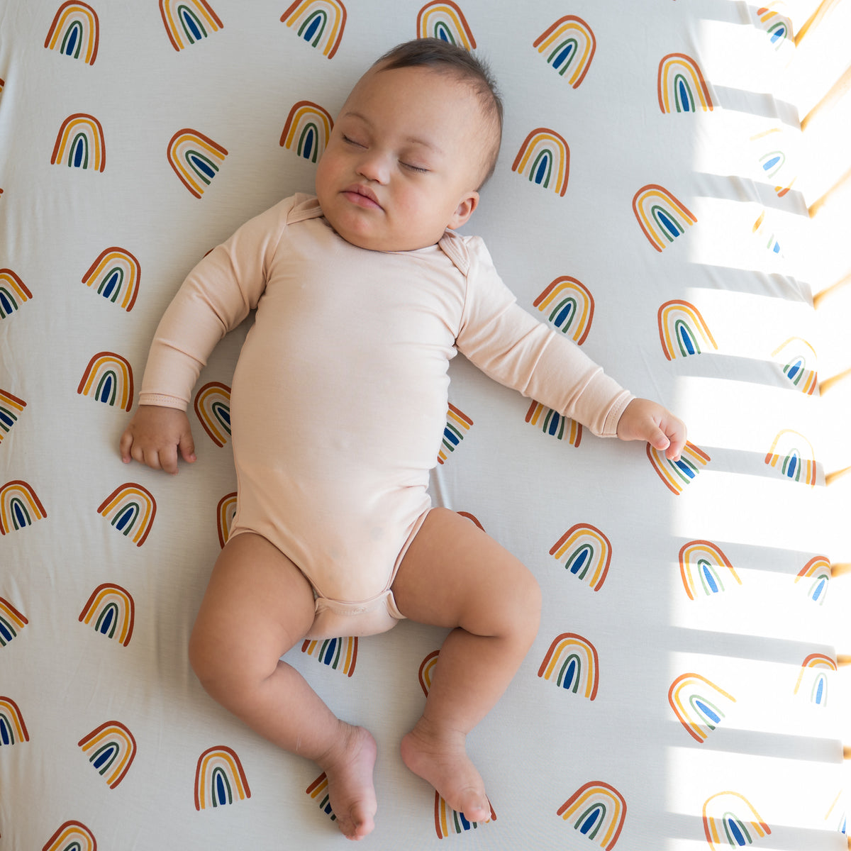 Baby sleeping on Crib Sheet in Rust Rainbow on Oat