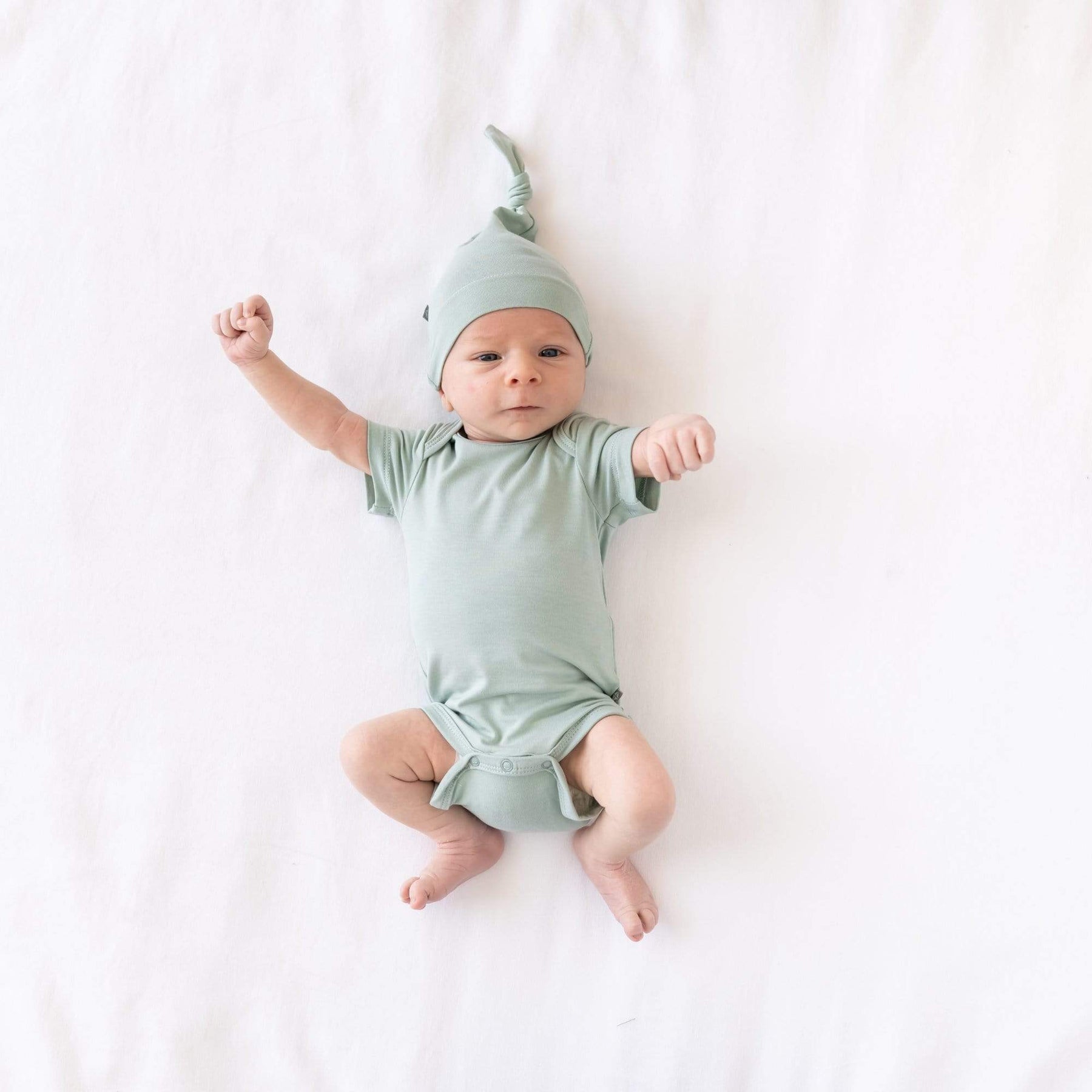 Newborn wearing  Knotted Cap in Sage and matching short sleeve bodysuit 