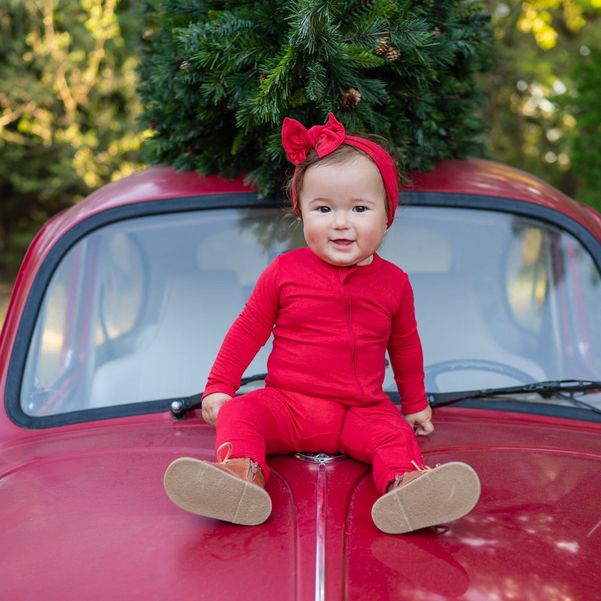 Infant wearing Kyte Baby Zippered Romper in Cardinal