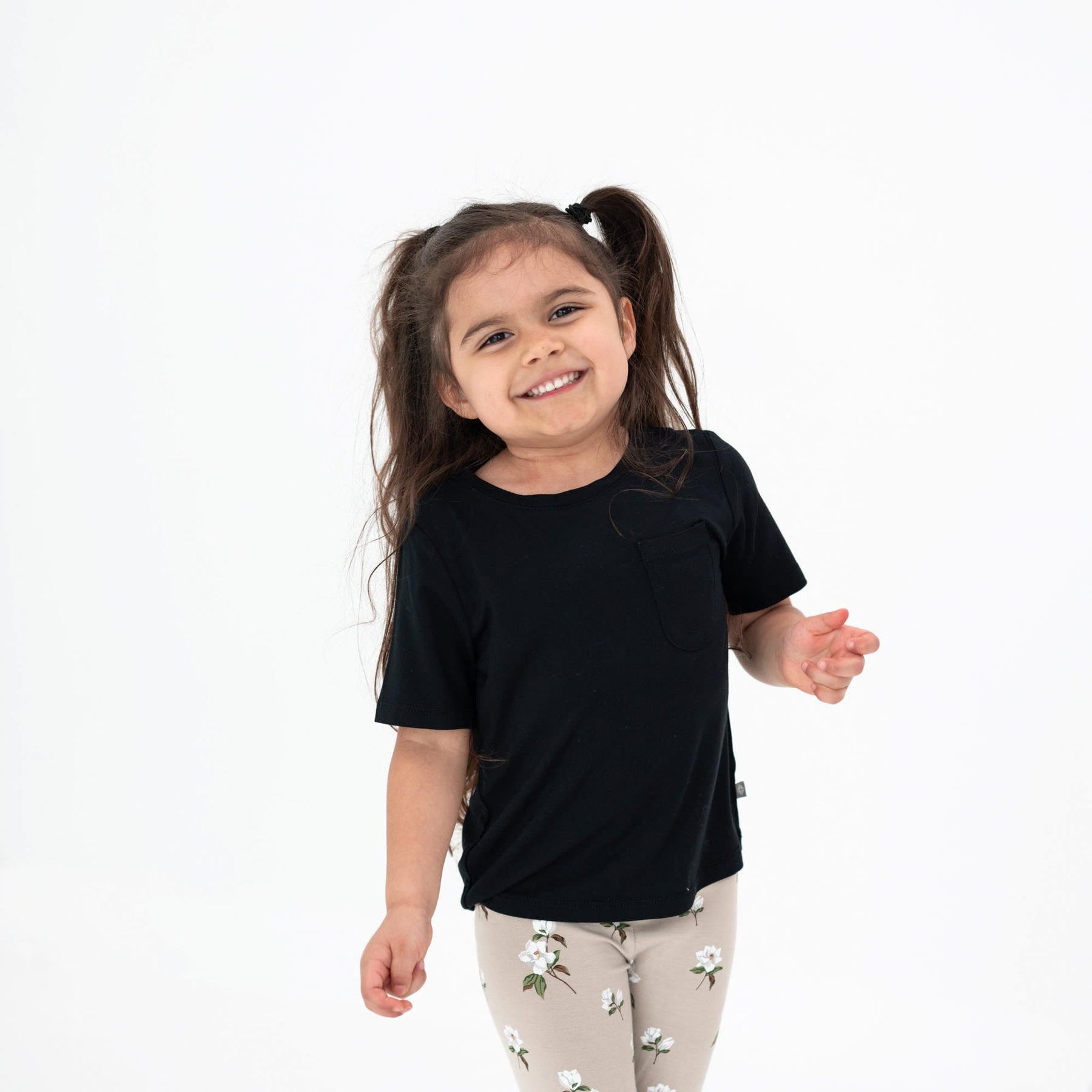 Smiling child wearing a Toddler Crew Neck Tee in Midnight and leggings in Oat Magnolia 