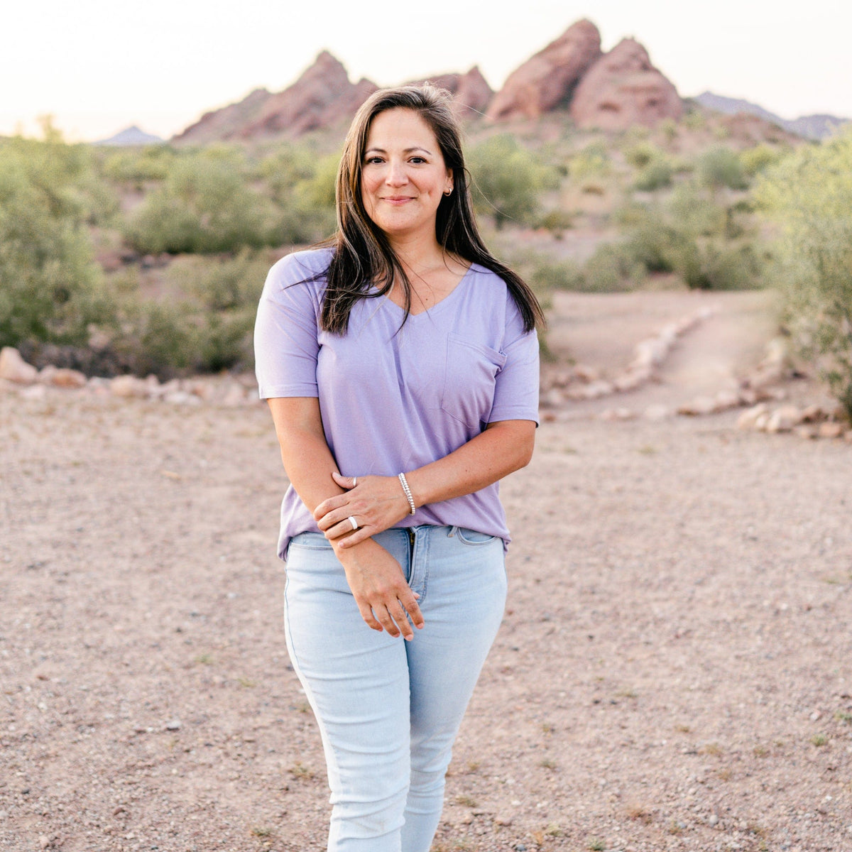 Female model standing in the desert wearing the Women’s Relaxed Fit V-Neck in Taro paired with light wash jeans